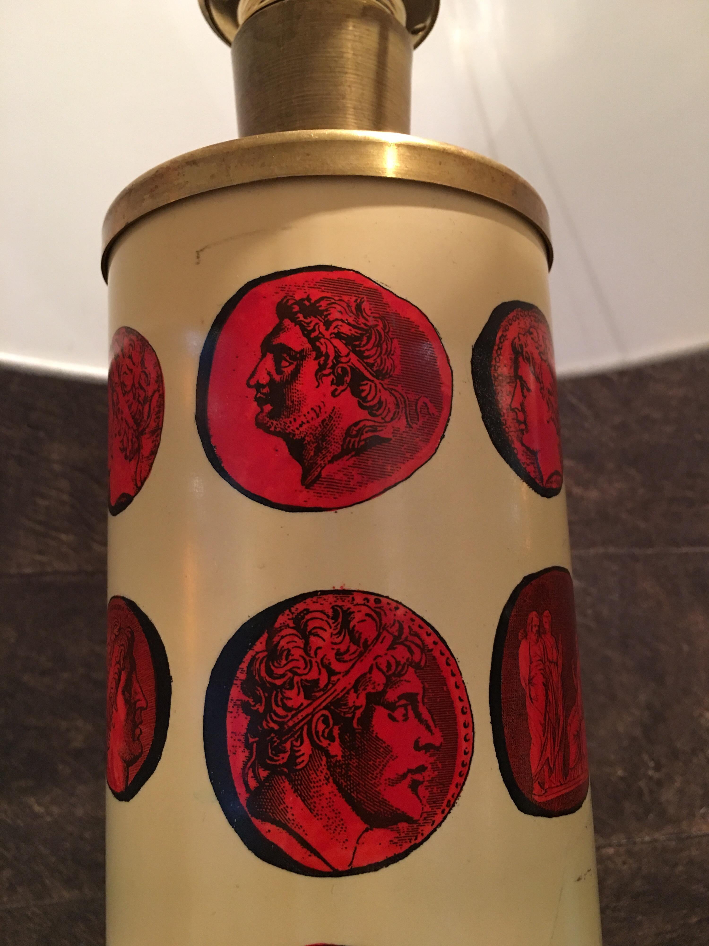 Enameled table lamp in white with red transfer printed lithographic cameos of emperors, and patinated brass.

The lacquered, cylindrical base features transfer images of Classical Roman figures on a parchment colored background from 18th century