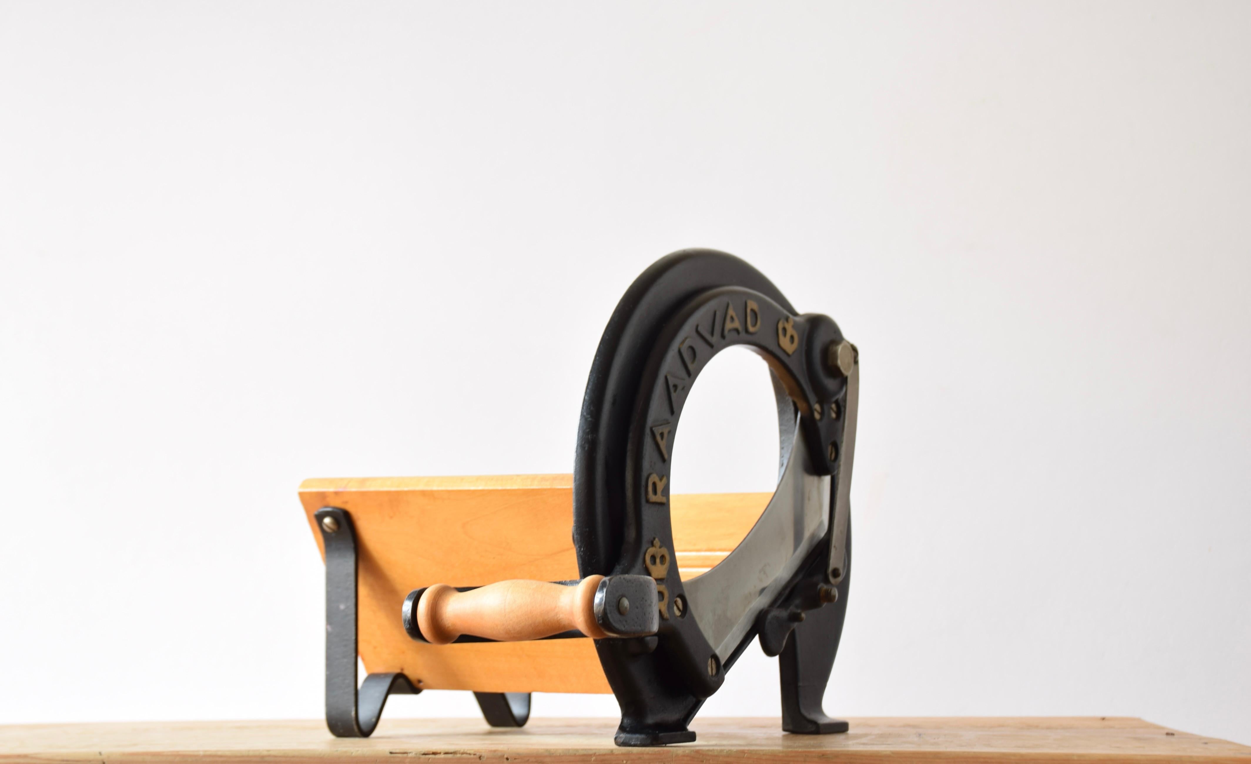 This iconic Danish bread slicer was produced by Raadvad in Denmark circa 1940s-1960s and designed in the 1930s. It comes with the original black lacquer and original golden letters. The bread slicer is fully functional for slicing bread, especially