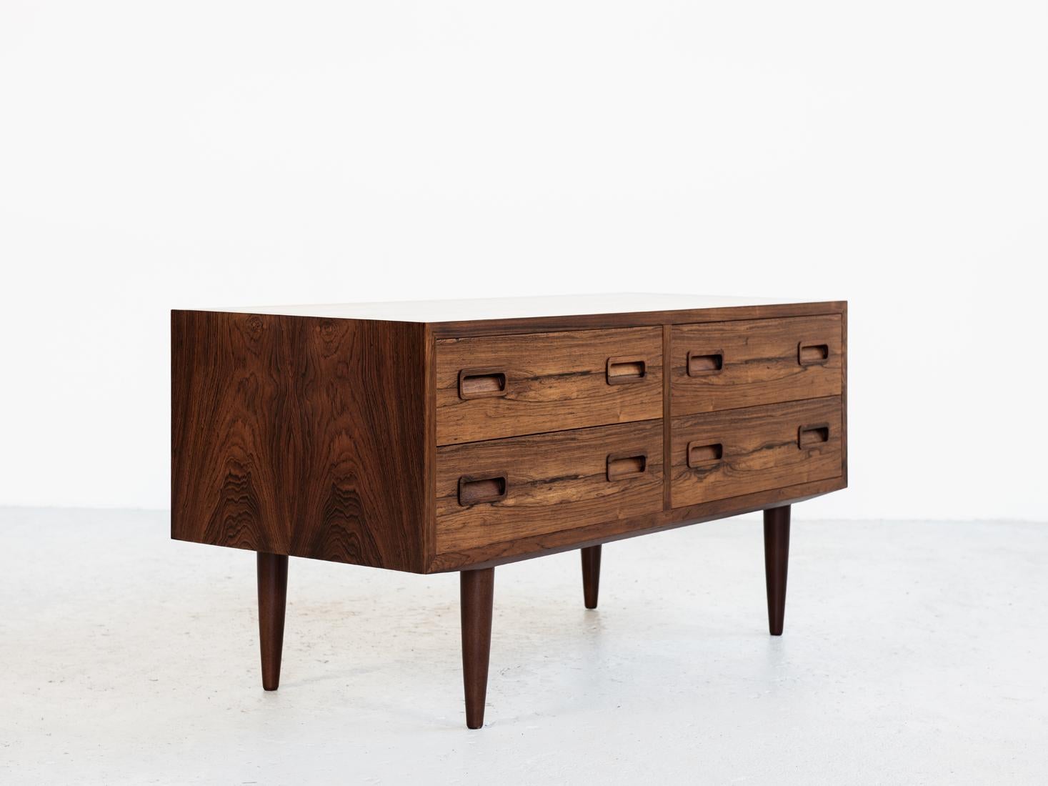 This midcentury Danish chest of 2x2 drawers in rosewood was manufactured by Hundevad in Denmark in the 1960s. It has beautiful drawings in the wood and has the typical shape of drawer handles. It is a proof of good quality manufacturing. This chest