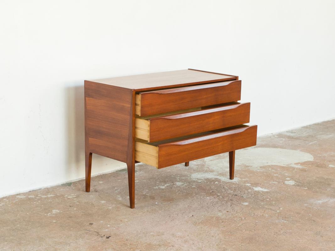 This midcentury Danish chest of 3 drawers in teak was designed and manufactured by Aksel Kjersgaard in Denmark in the 1960s. It has a very beautiful design. Look how the legs continue in the body of the chest! It has beautiful drawings in the wood.