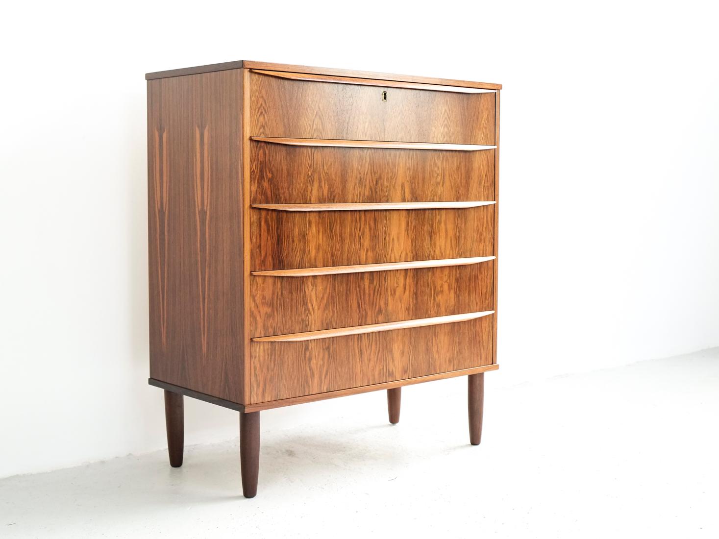 This midcentury Danish chest of 5 drawers in rosewood was made in Denmark in the 1960s. It has beautiful veneer selection and long drawer handles. The chest was made with the best materials and very good quality manufacturing. It is in rosewood and