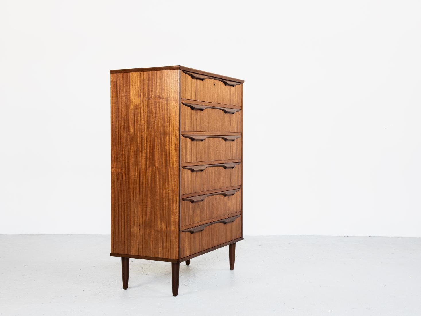 This midcentury Danish chest of 6 drawers in teak was designed by Klaus Okholm and made in Denmark in the 1960s. This chest shows high quality manufacturing with the best materials and real craftsmanship. It has beautiful drawer handles. This chest