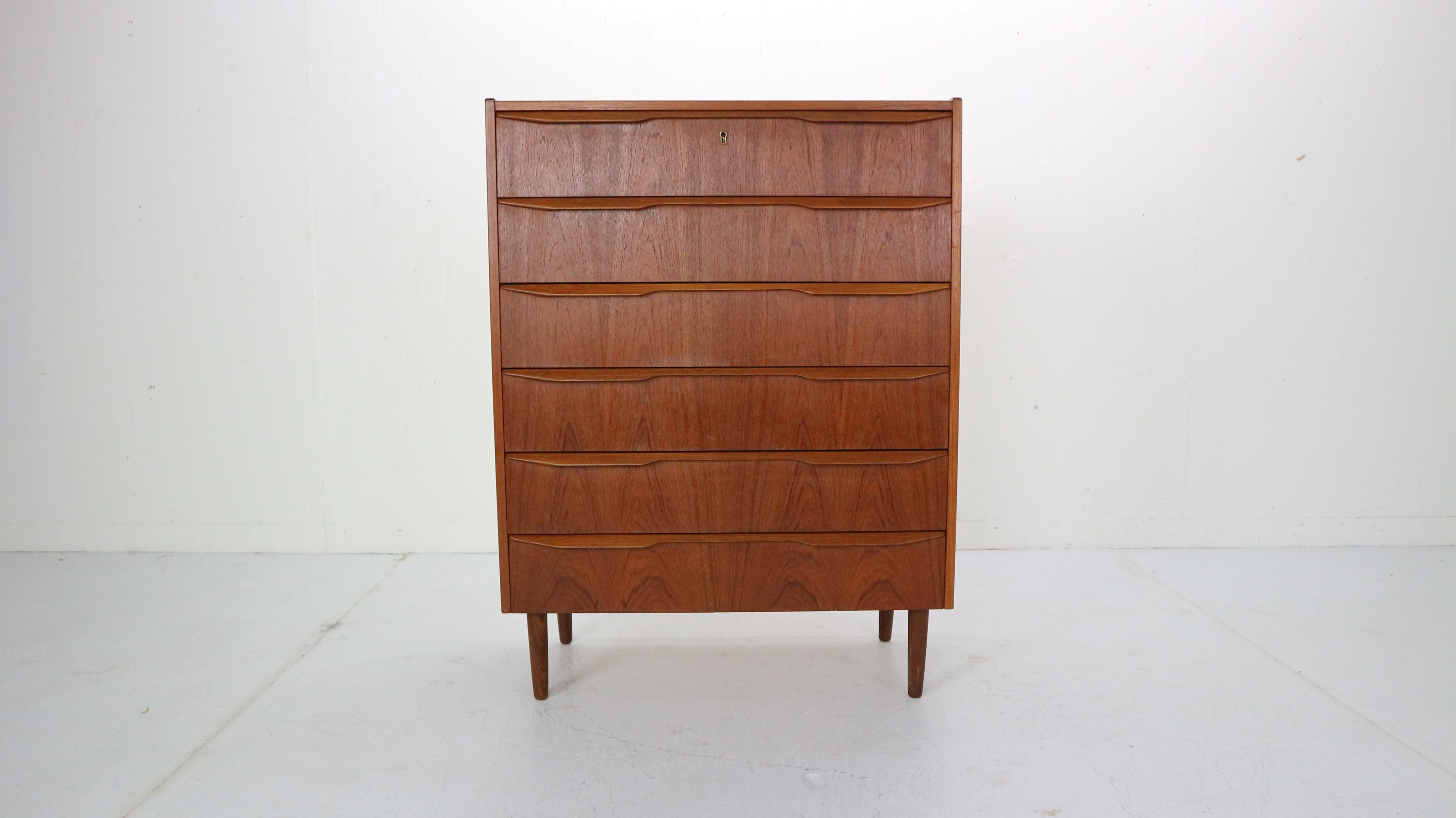 This midcentury Danish chest of 7 drawers in teak was made in Denmark in the 1960s. It has beautiful finer selection and long drawer handles in 2 parts in solid teak. It has beautiful drawings in the wood.
  
