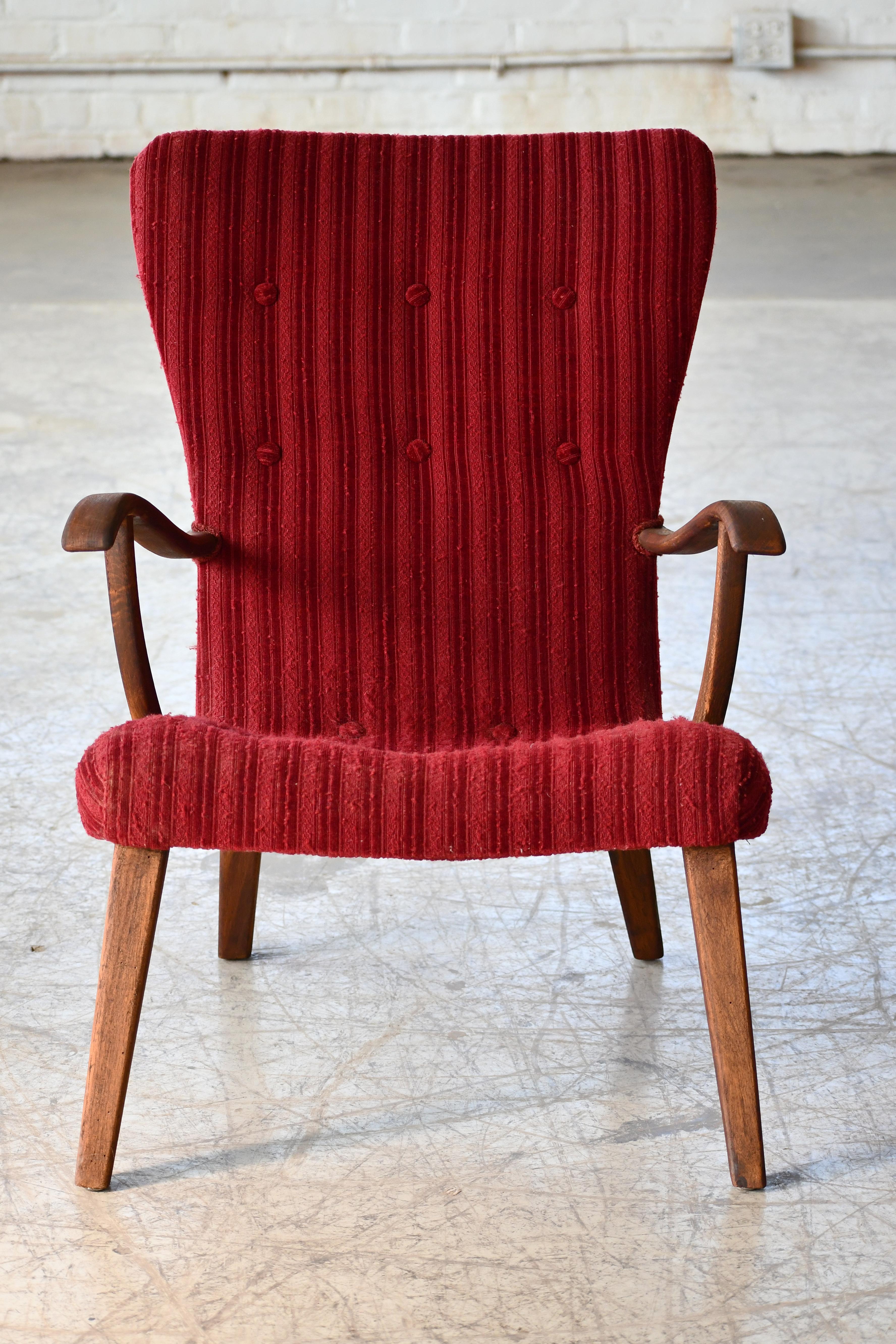 Charming lounge chair made in Denmark from stained and varnished beech wood. The design bears resemblance to the famous Pragh by famed maker, Schubell and Madsen and also has a stance and silhouette similar to Phillip Arctander's famous clam chair.