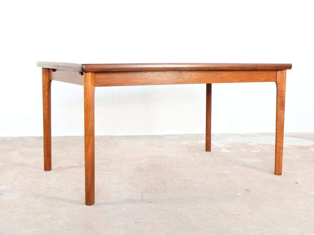 Midcentury Danish dining table designed by Henning Kjaernulf for Vejle Stole & Møbelfabrik. The table is extendable on either one or both sides. The extension plates are covered by the border on the tabletop. The legs are at the end of the table and