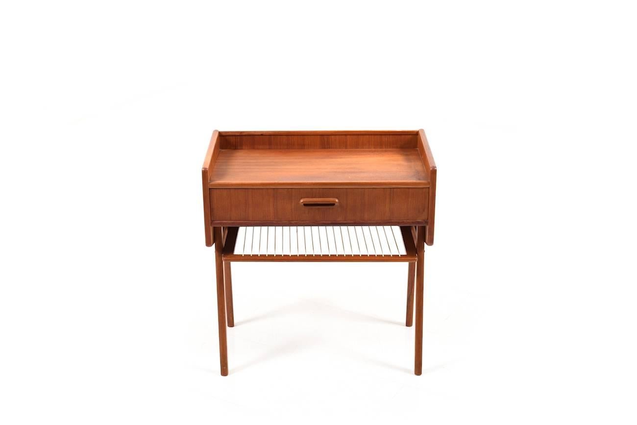 Midcentury Danish entry chest/ table in teak. Front with one drawer. Below the drawer with a small storage compartment.