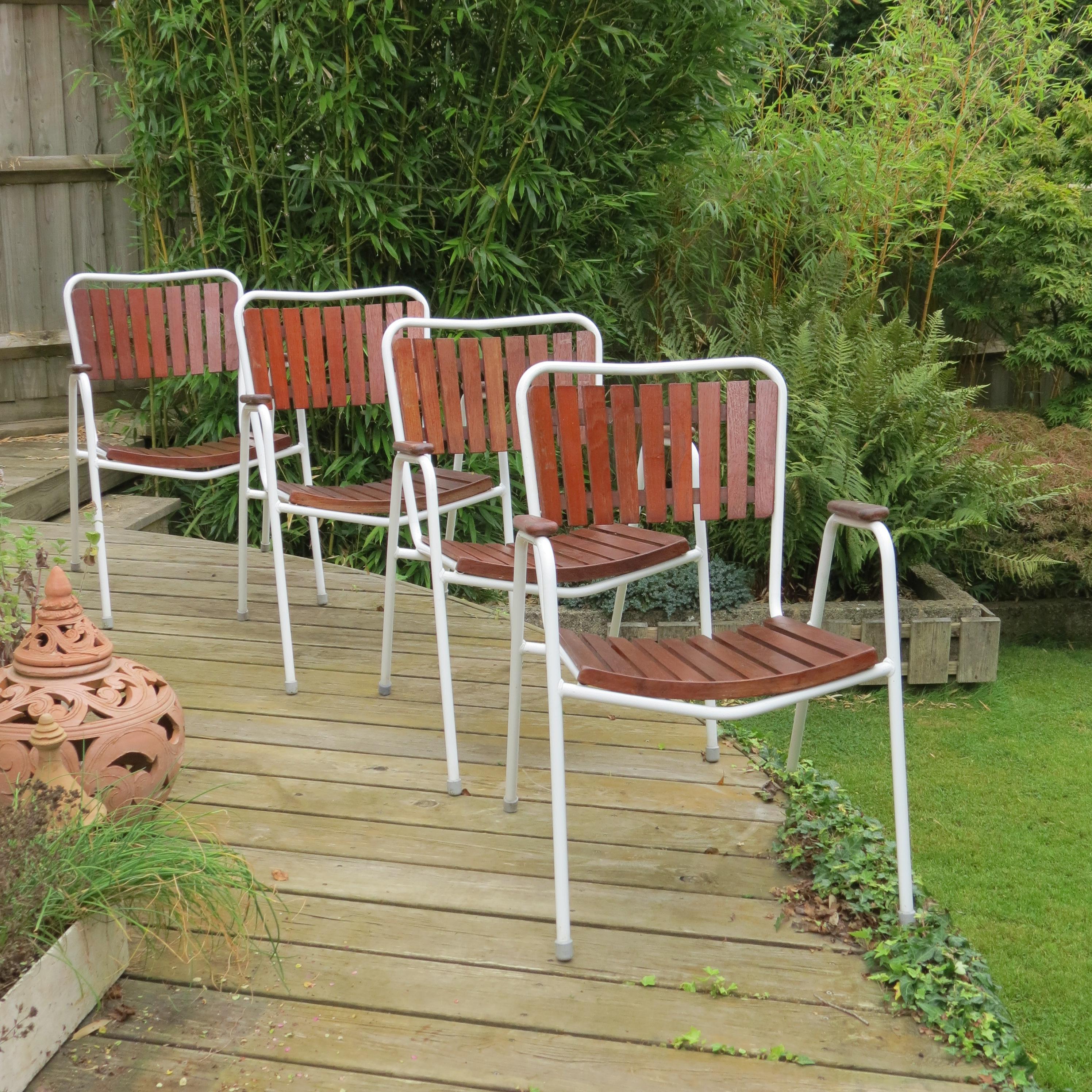 Wonderful garden set comprising four stacking garden chairs and a folding garden table.  Designed and produced by Daneline, Denmark.  

Plastic coated steel tube frames with solid Teak slatted seat and backs. The chairs stack and the table legs fold