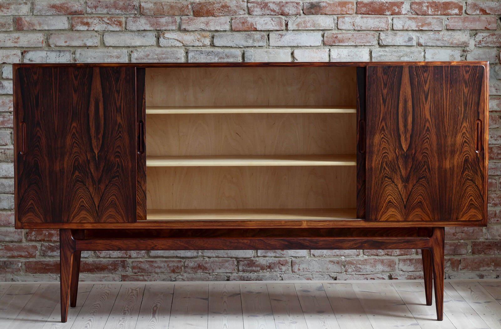 Danish highboard in beautiful rosewood veneer. The piece was designed and made in 1960s and is a great example of Danish midcentury design in its best. It features three storage sections that provide lots of space. The middle section has two large