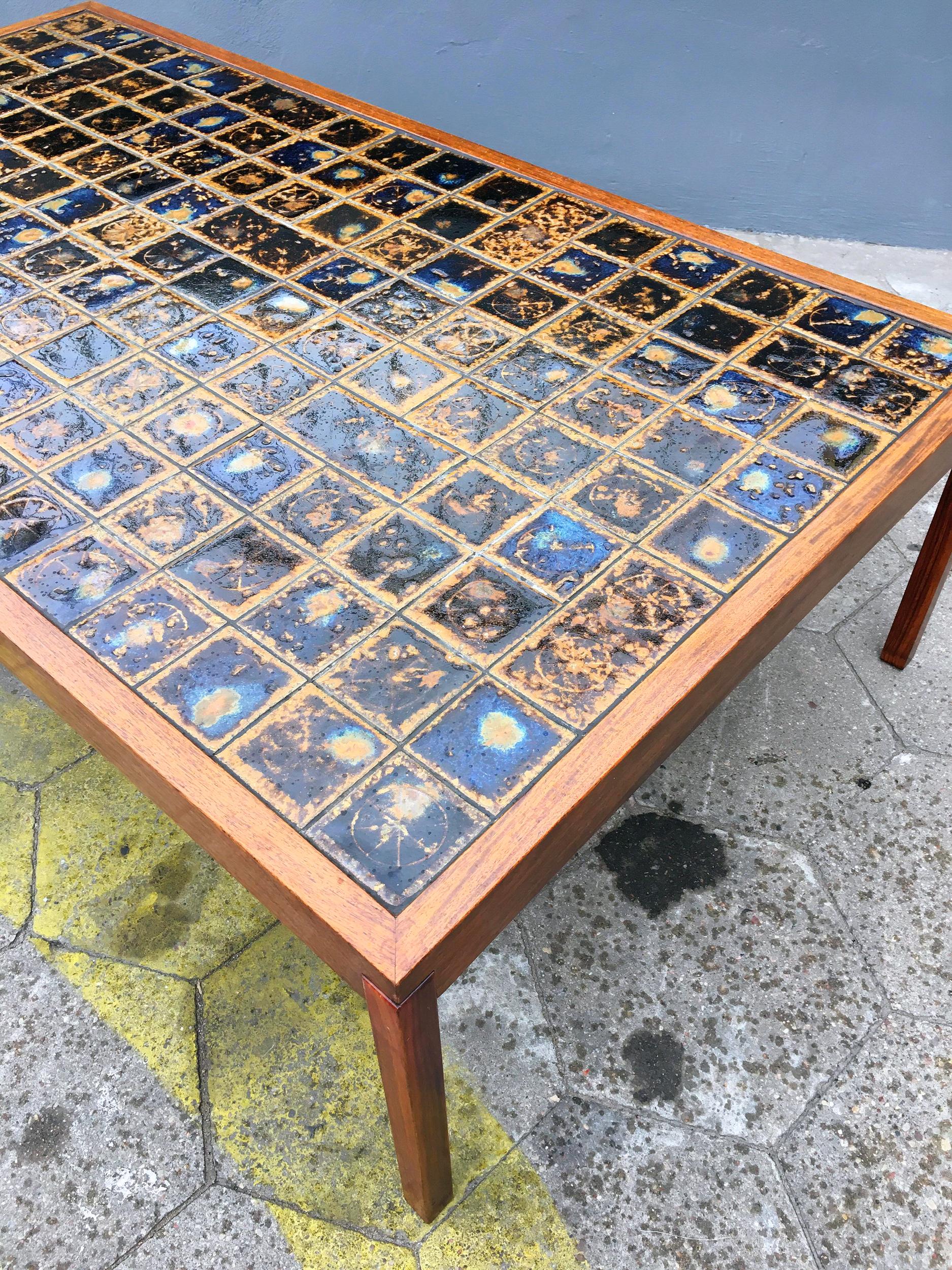This teak wood coffee table was made in 1960s, which has no influence on his condition, which I would call ideal. The wooden surfaces are intact, also the top made of opal-colored, dark blue ceramic tiles is in perfect condition. The only thing you