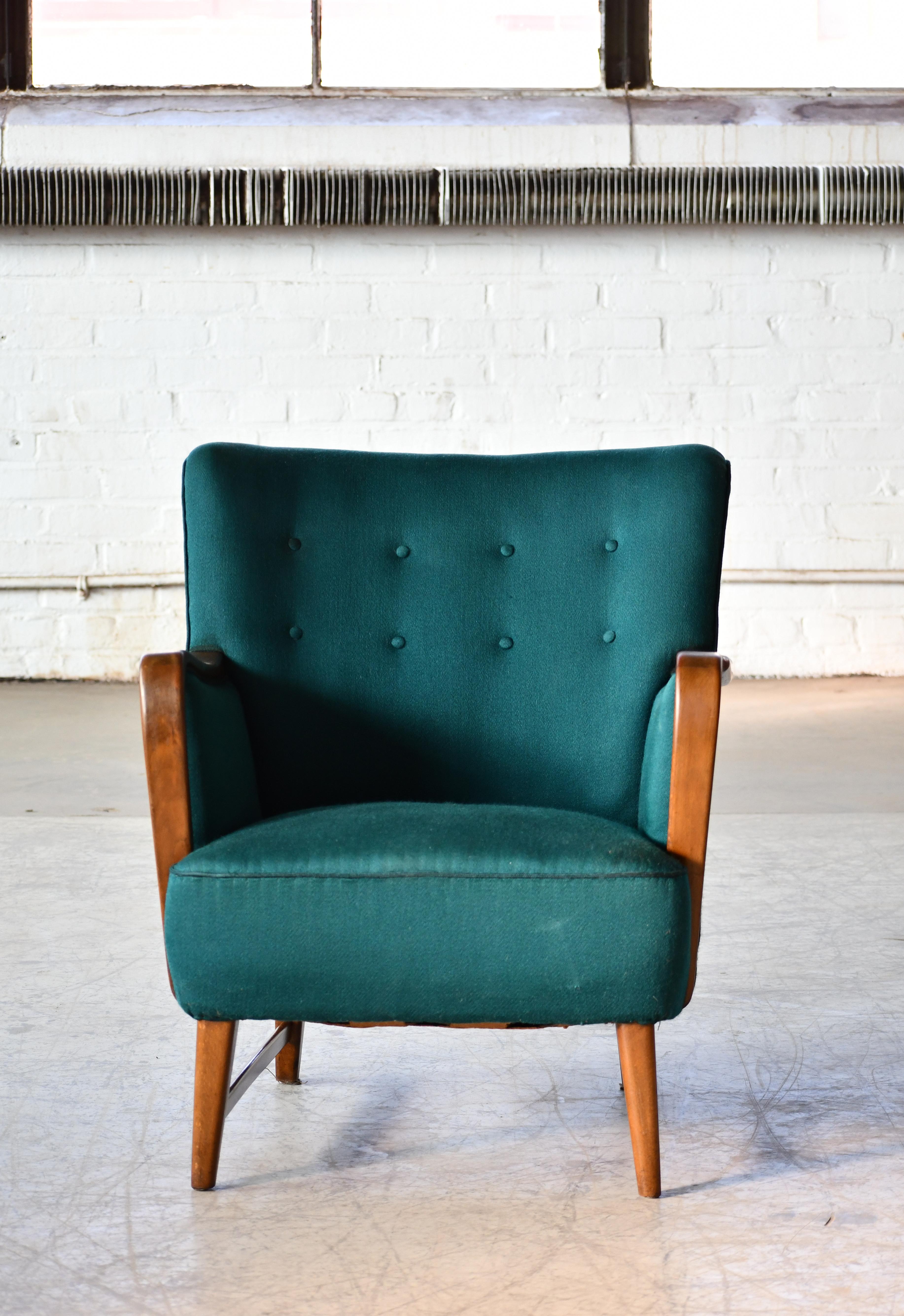 Super charming 1950s lounge chair with armrests and base in a nice golden solid oak. Designed by Kurt Olsen around 1950 for N.A. Jorgensen. N.A. Jorgensen became known as Bramin Mobler in 1958 well known for making traditional Danish furniture of