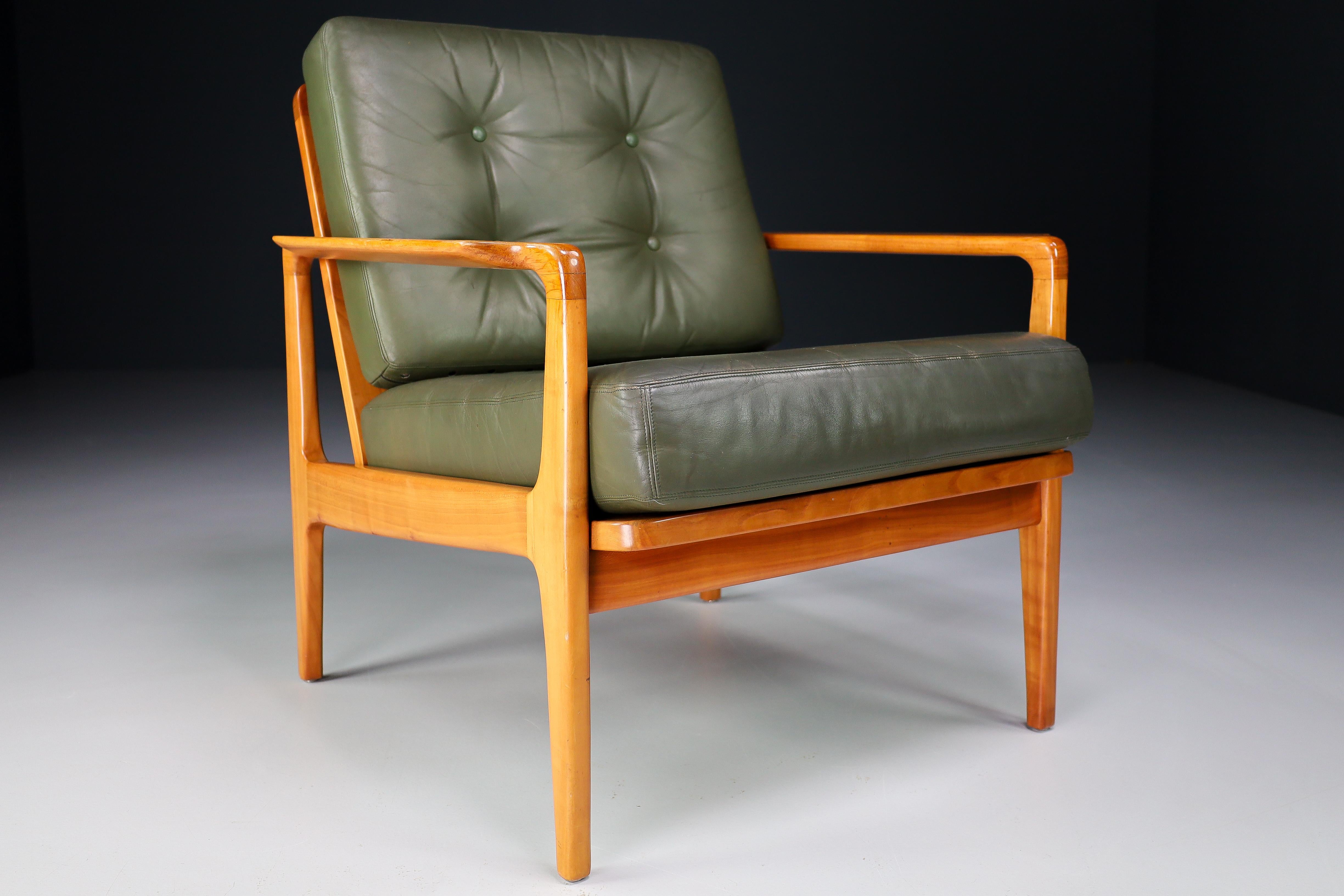 Midcentury Danish lounge chairs by Arne Wahl Iversen in green leather, Denmark 1960s. These armchairs would make an eye-catching addition to any interior such as living room, family room, screening room or even in the office. It also perfectly fits