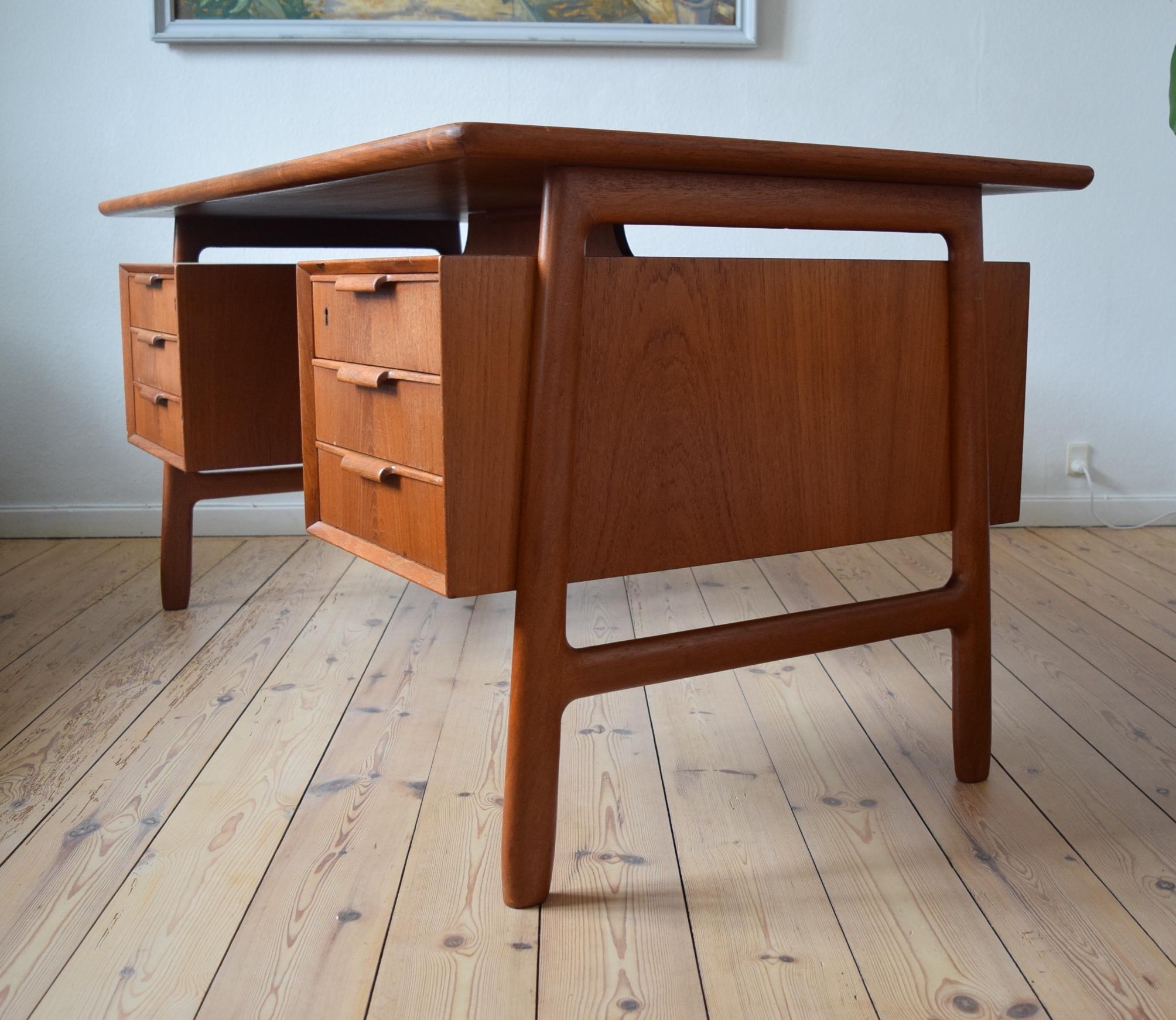 Mid-Century Modern, model 75 executive desk dating from the 1960s. The refinished vintage desk features six drawers with sculpted wood pulls. Additional storage space is found on the backside with two open bookshelves and a fall-front compartment.