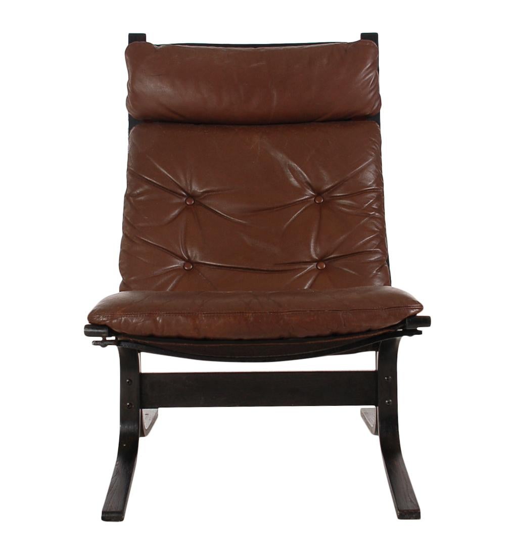 A Classic high-back sling chair designed by Ingmar Relling for Westnofa Furniture Company. These model features ebonized wood frame with canvas and leather sling.