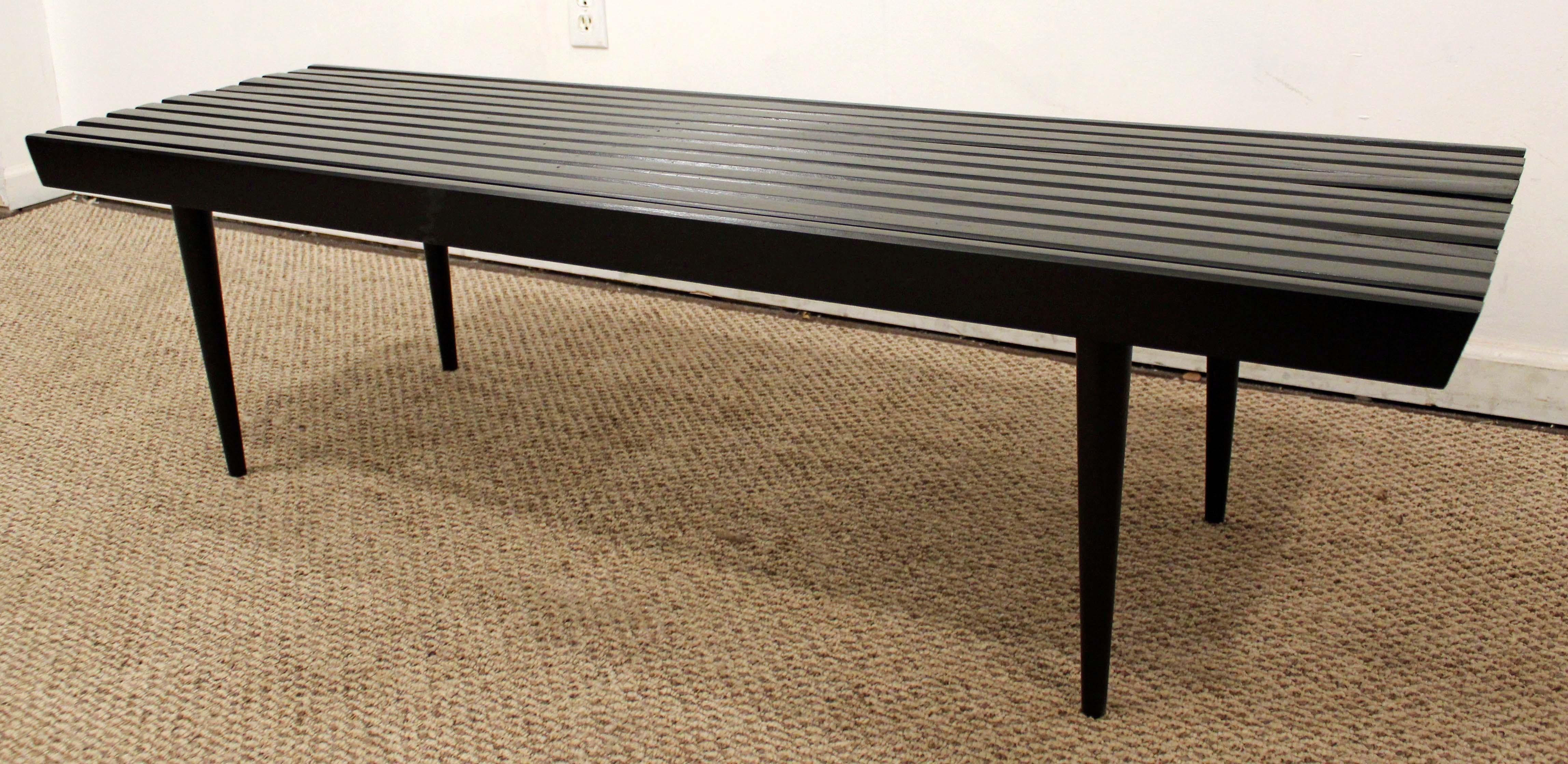 What a find. Offered is a midcentury slat bench coffee table. It is made of walnut and has been painted black. The piece is in excellent condition considering its age. It is not signed. 

Dimensions: 
60