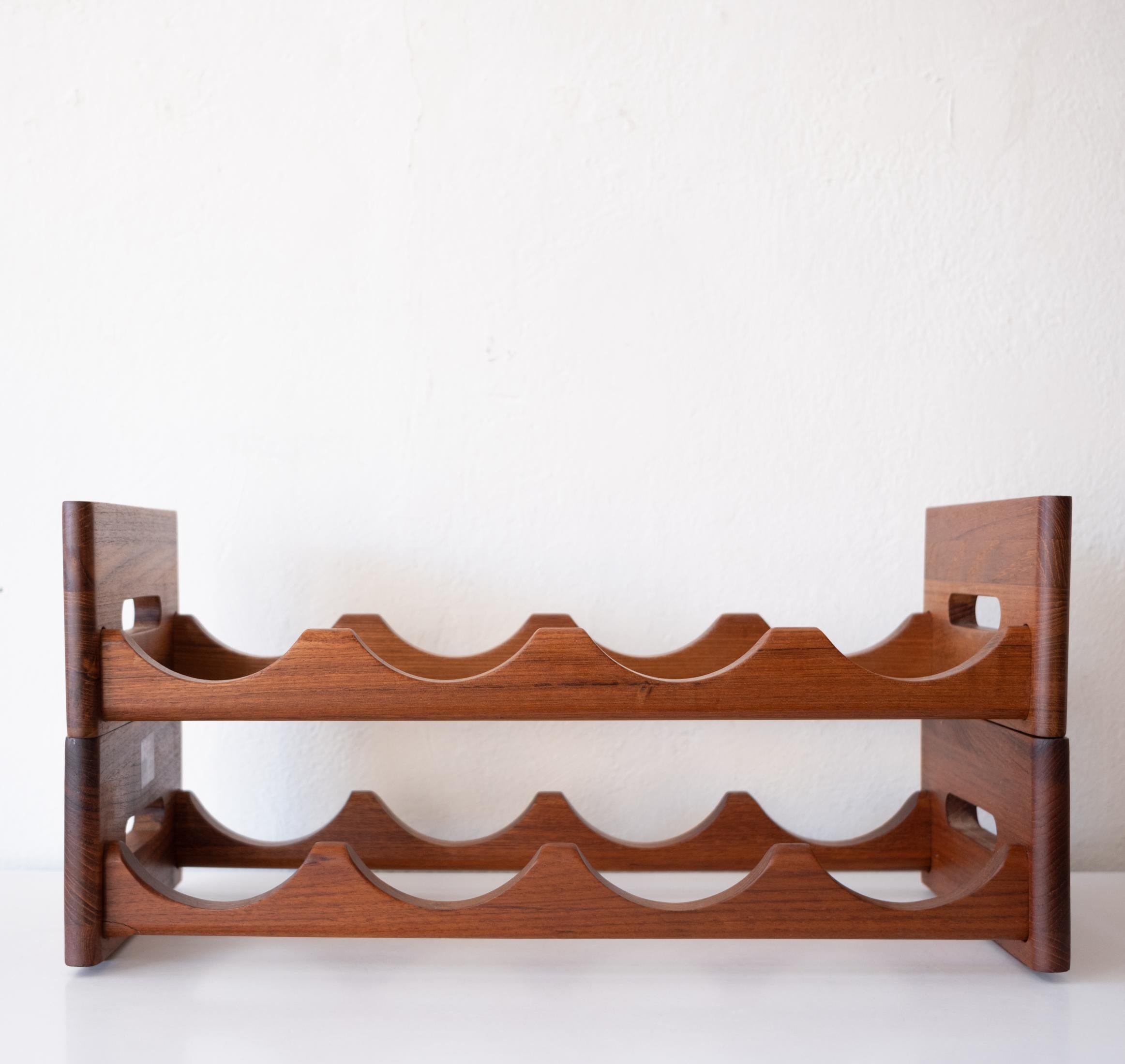 A pair of Kalmar solid teak wine bottle racks. They appear to have never been used and include the original label. Kalmar was Danish company which produced items in Thailand and Denmark. 

Each rack holds four bottles and measures 9