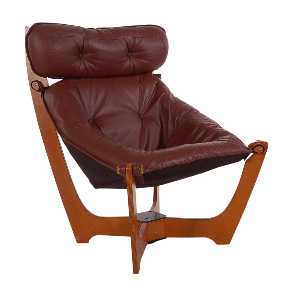 A Classic Danish design by Odd Knutson. This model has the higher back with headrest. It features a brownish-burgundy leather sling on teak frame. Very comfortable chair.