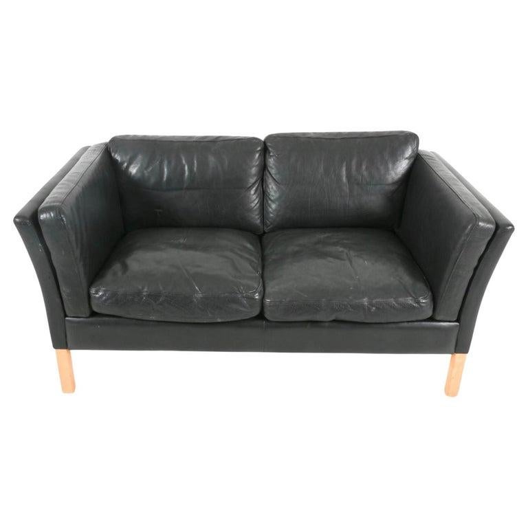 Symmetry MMid Century Scandinavian modern Curved arm Low Mid century Danish modern Canapé 2 places en cuir noir avec pieds en bois de bouleau. Style de Børge Mogensen. Le beau cuir noir épais est souple et présente des signes d'utilisation, mais il