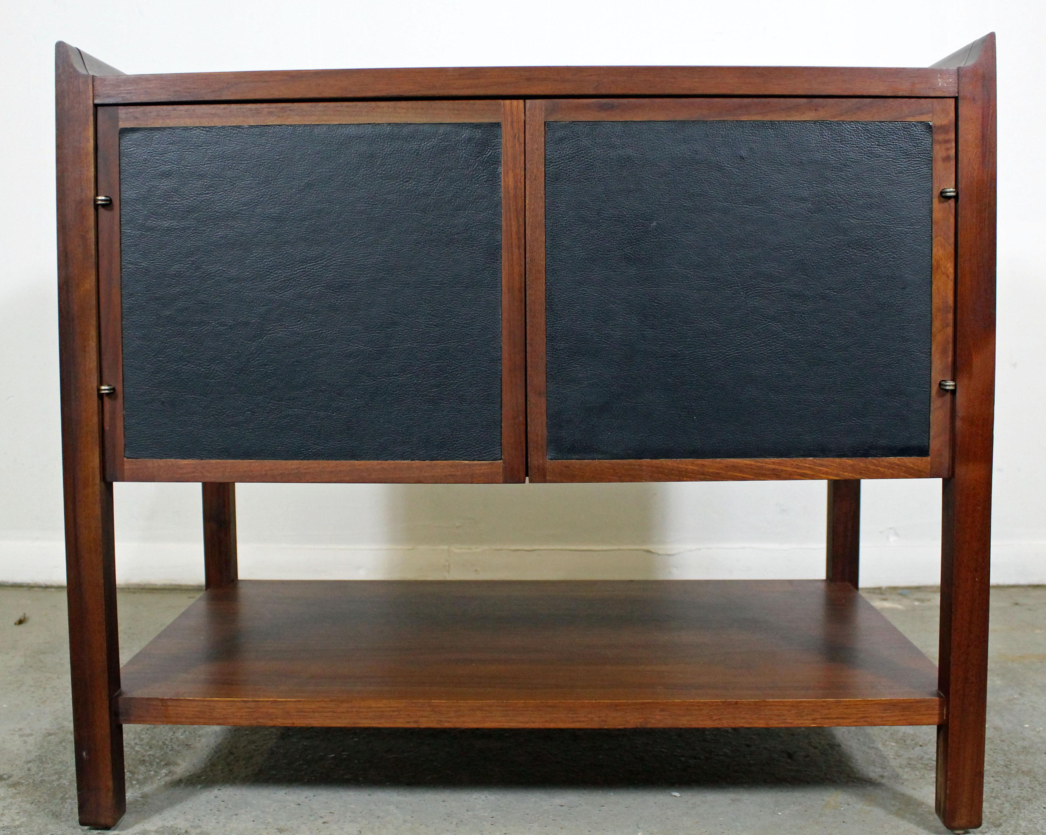 What a find! Offered is a Mid-Century Modern end table with flared edges, cabinet, and bottom shelf. It is in excellent condition for its age, shows minor wear (light surface scratch/wear -- see pictures). It is not signed.

Dimensions:
26