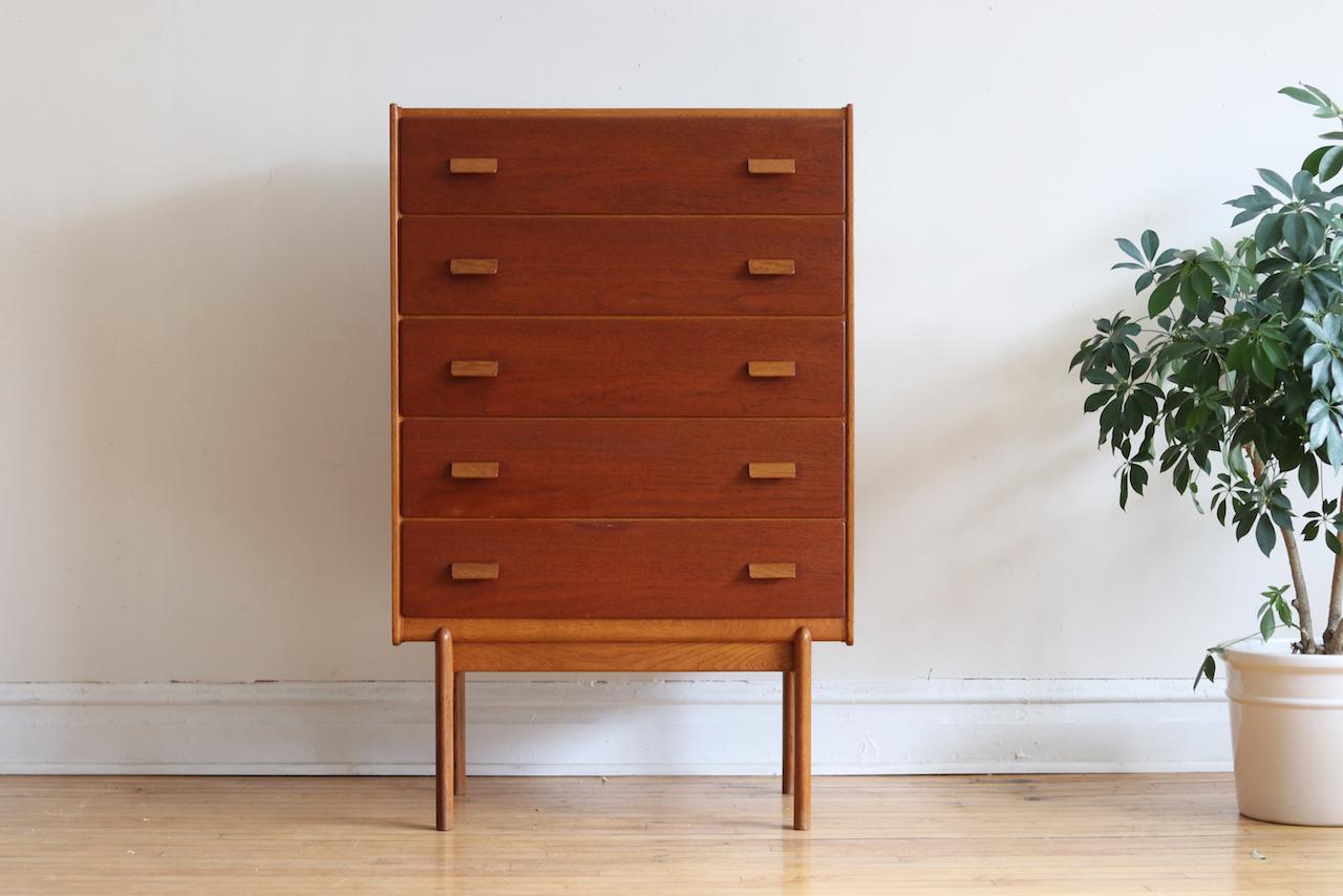 Mid-Century Modern Danish chest of drawers.
Just imported from Copenhagen!
Oak base and handles with Teak drawer fronts. 
Five dovetailed drawers with two wooden handles on each drawer.
Long unique legs.
Excellent vintage condition. Minor