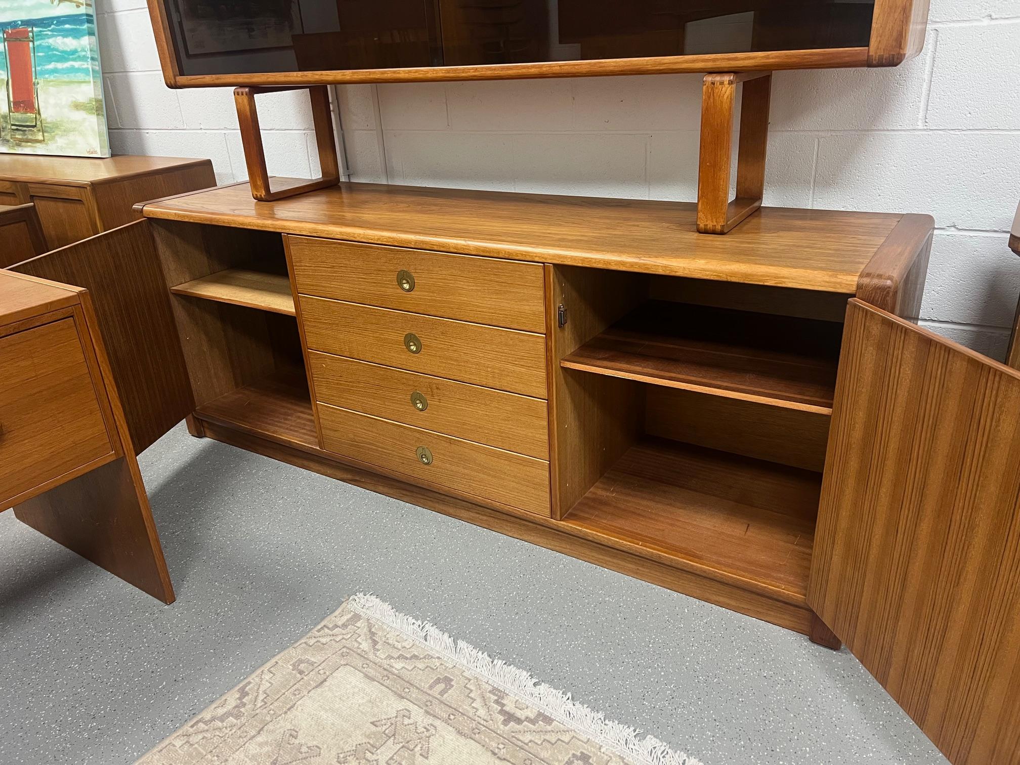 Outstanding teak credenza or buffet with hard to find top hutch by D-Scan. Model Captain Line. Lots of storage. Adjustable shelves. Brass handles. The top is removable. Very good condition. Clean drawers all open and close well. Some minor marks