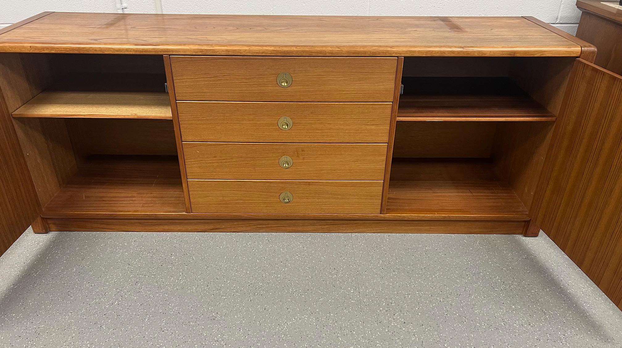 This beautiful midcentury Danish modern teak credenza buffet is the perfect addition to any home. Crafted by D-Scan in their Captain Line, this piece boasts a rich brown color and is made from high-quality teak material. Having two cabinets with