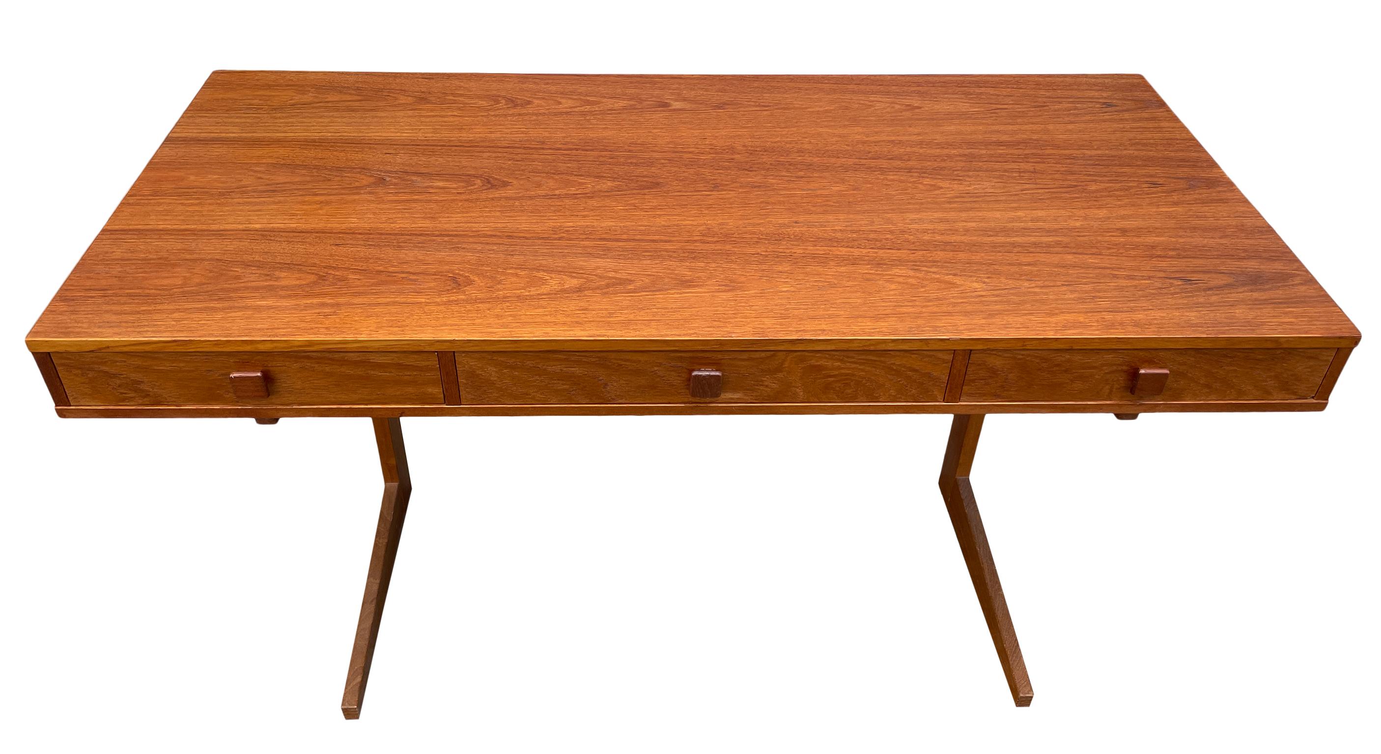 Gorgeous Teak minimalist desk featuring on a floating rectangular form with three drawers and a solid teak trestle base. The drawers easily slide and are very clean. Fantastic original vintage condition and ready for use. Danish mid century design.
