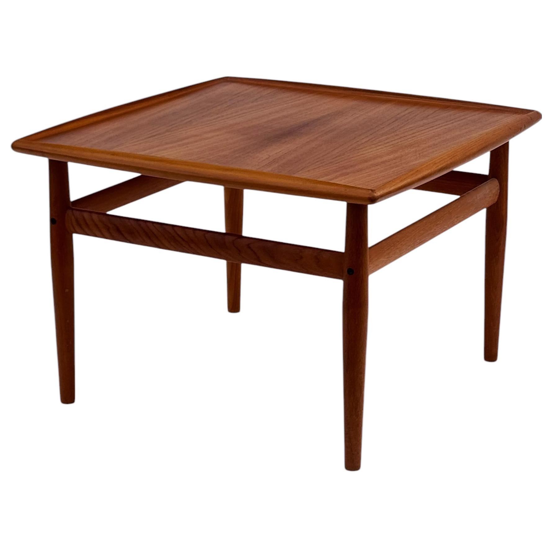 Un classique scandinave conçu par Grete Jalk et fabriqué par Glostrup au Danemark, vers les années 1960. La table est fabriquée en teck massif avec un grain magnifique. 