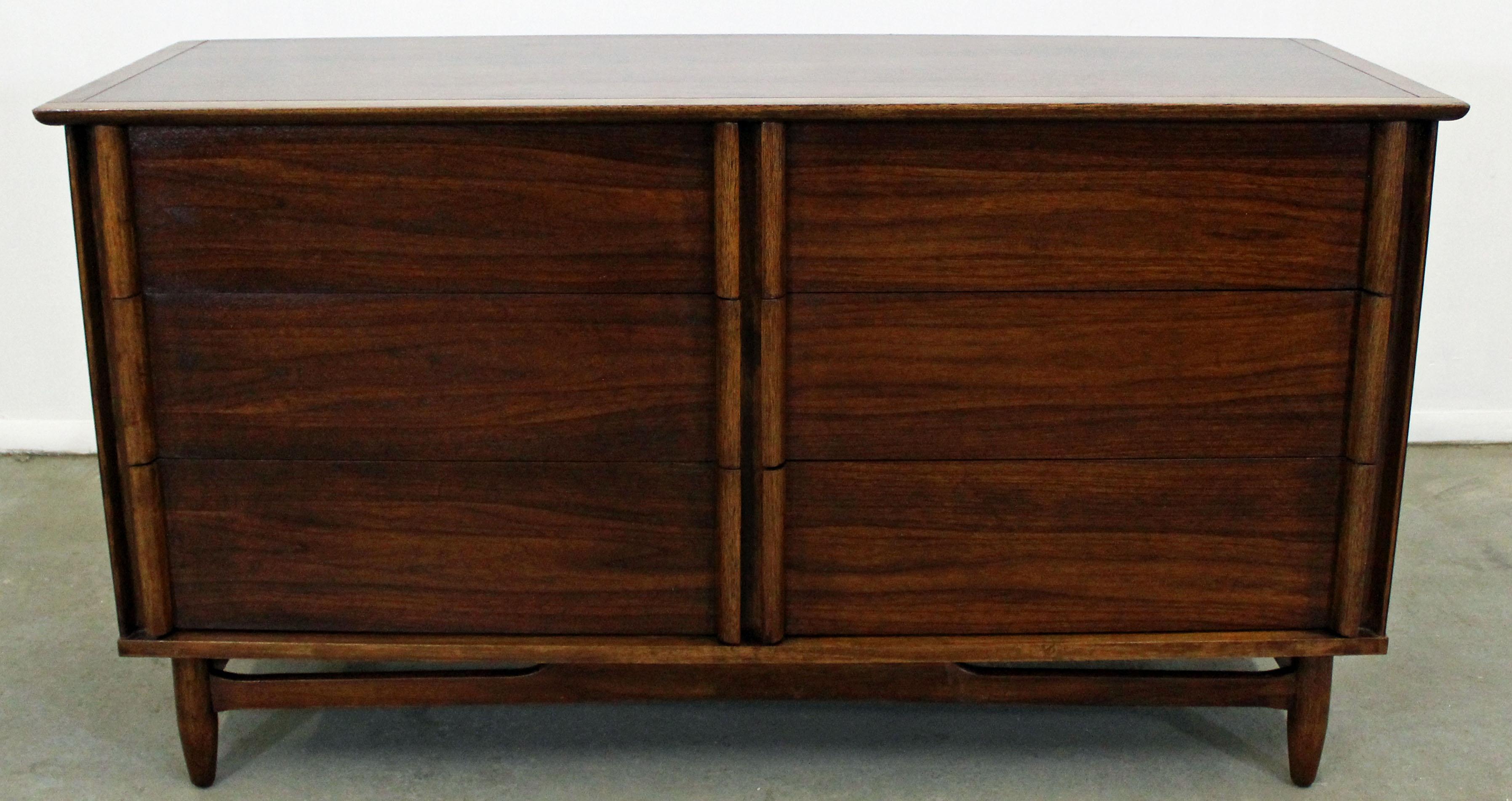 What a find. Offered is a gorgeous mid-century modern walnut dresser with flared edges and six drawers (not dovetailed). The two top right drawers have dividers (see pics). It is in very good condition for its age, has been refinished, shows minor