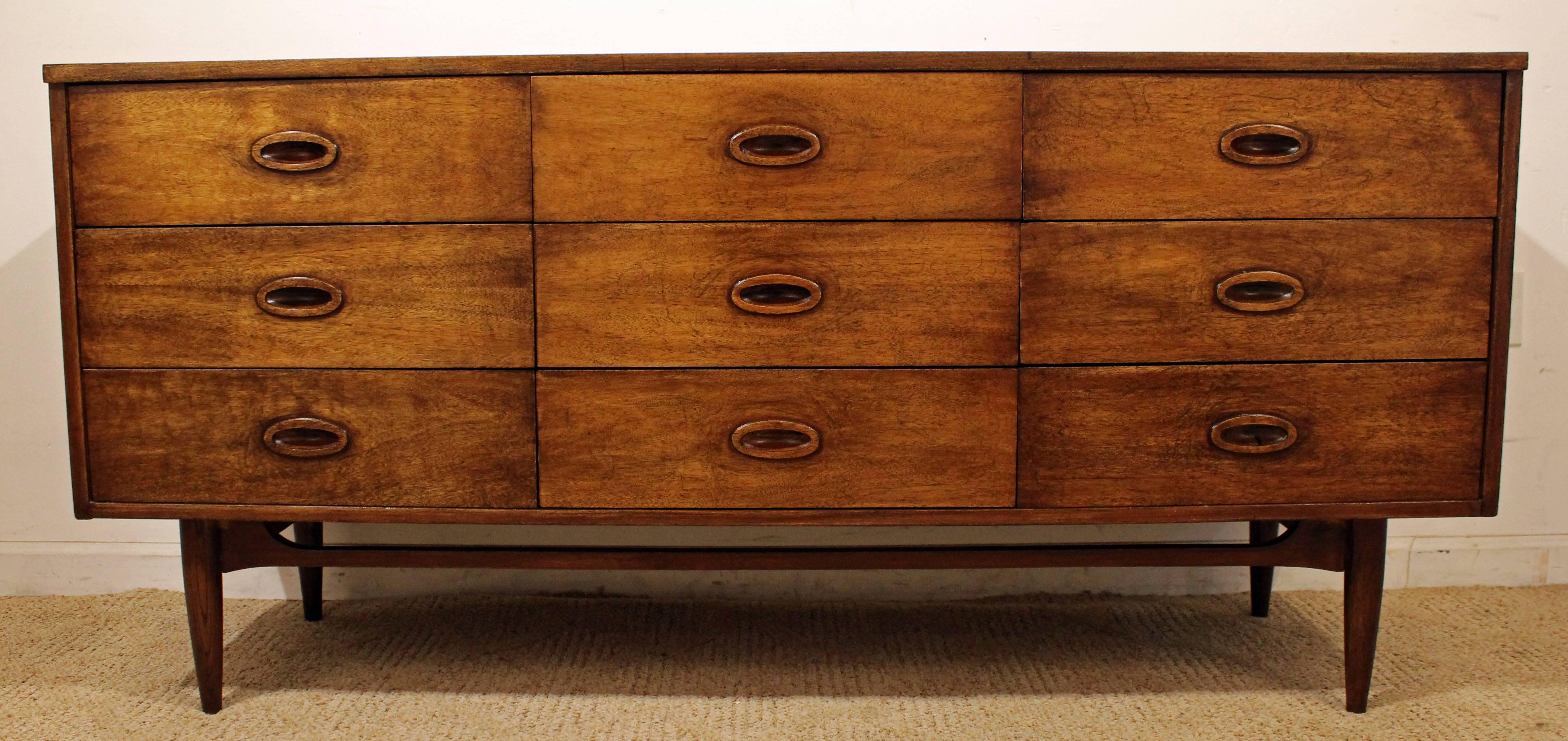 Offered is a Mid-Century Modern dresser. It is made of walnut, featuring  nine dovetailed drawers with recessed pulls. It is marked by Dixie. 

Dimension: 
64.25
