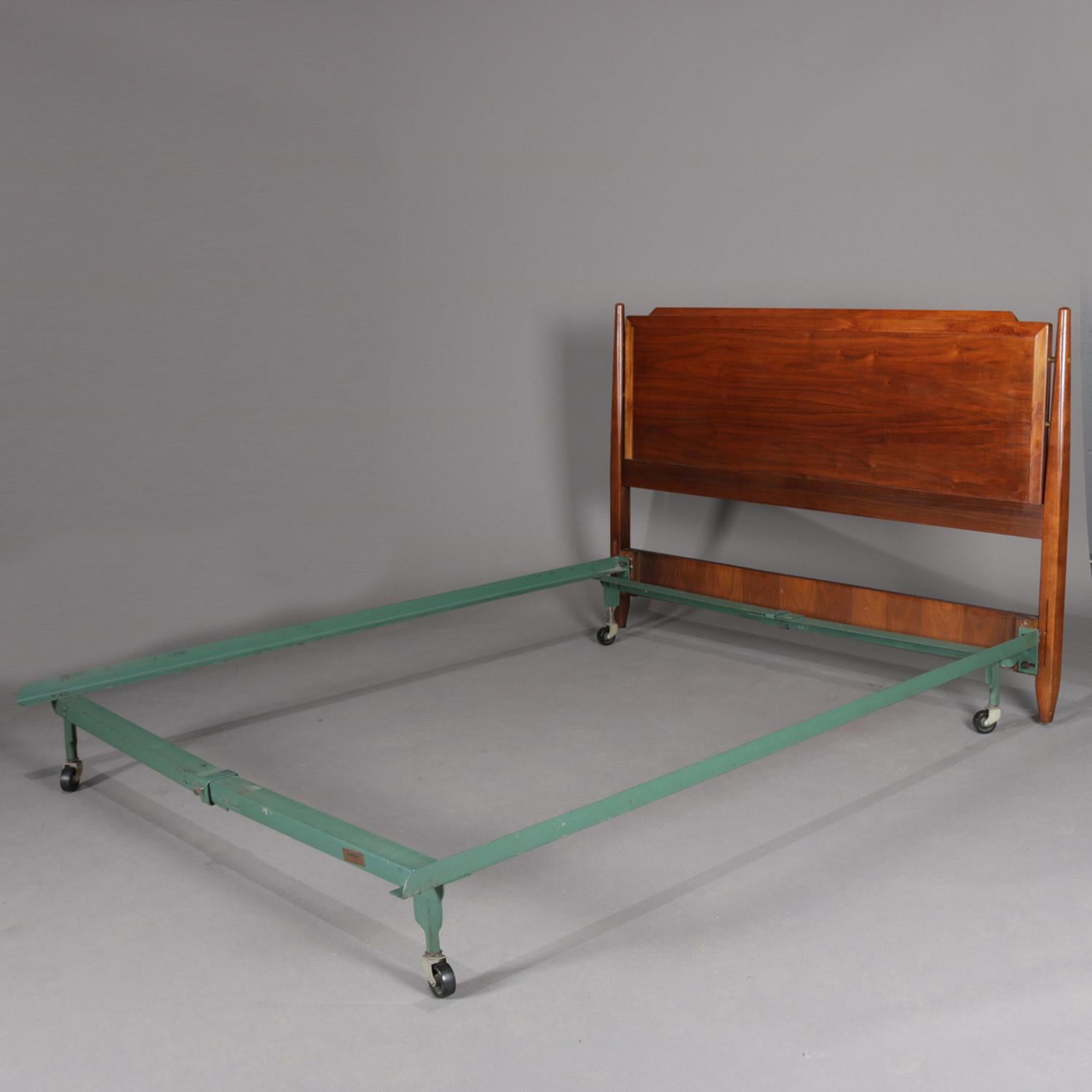 Midcentury Danish modern full/double bed frame features panelled walnut headboard having flanking turned column supports and collapsible metal frame, 20th century.


Measures: 36.5