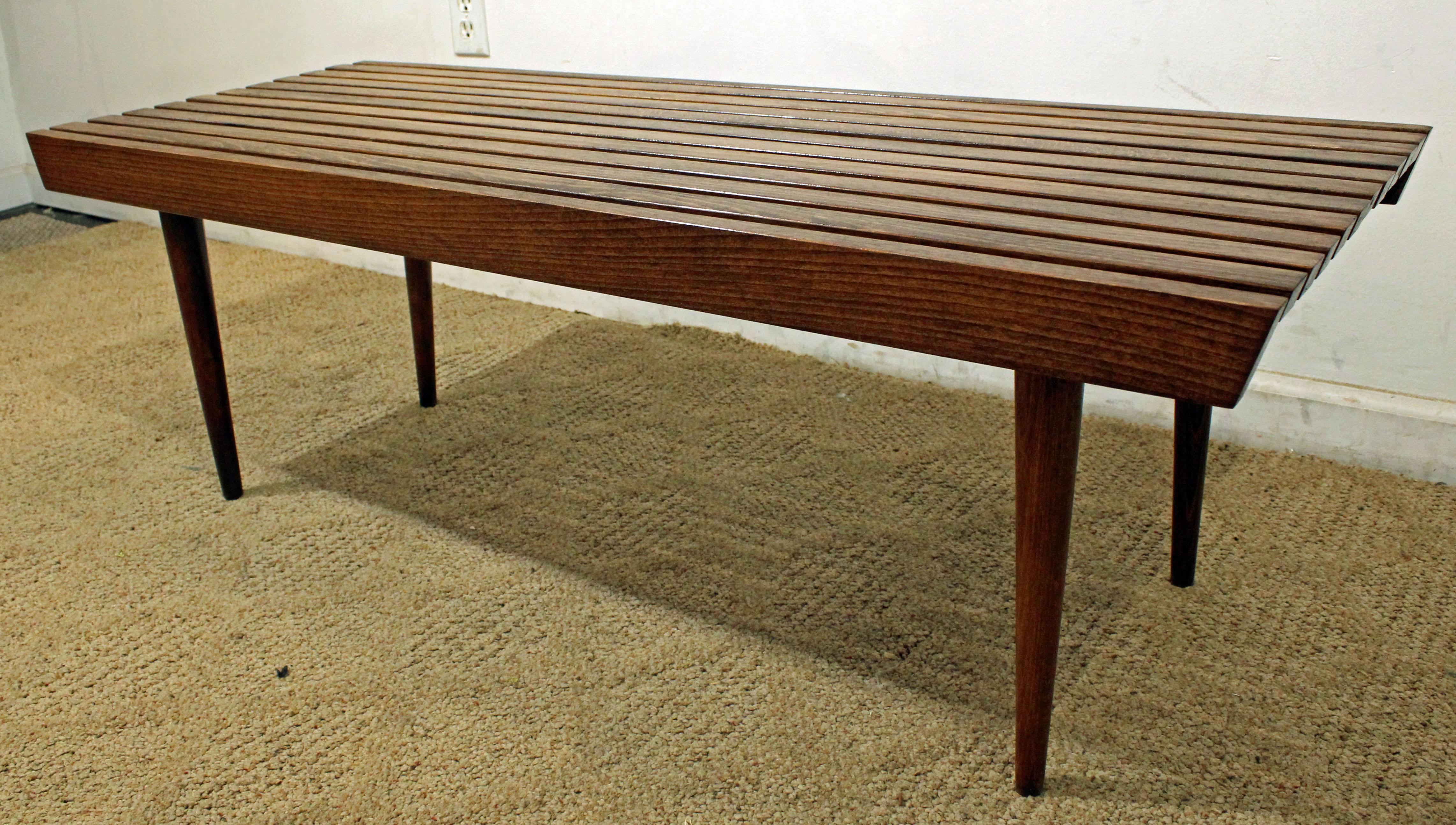 What a find. Offered is a Mid-Century Modern walnut slat bench coffee table. It has a nice look and simple lines. The piece shows minor wear. It is not signed. 

Dimensions: 
48