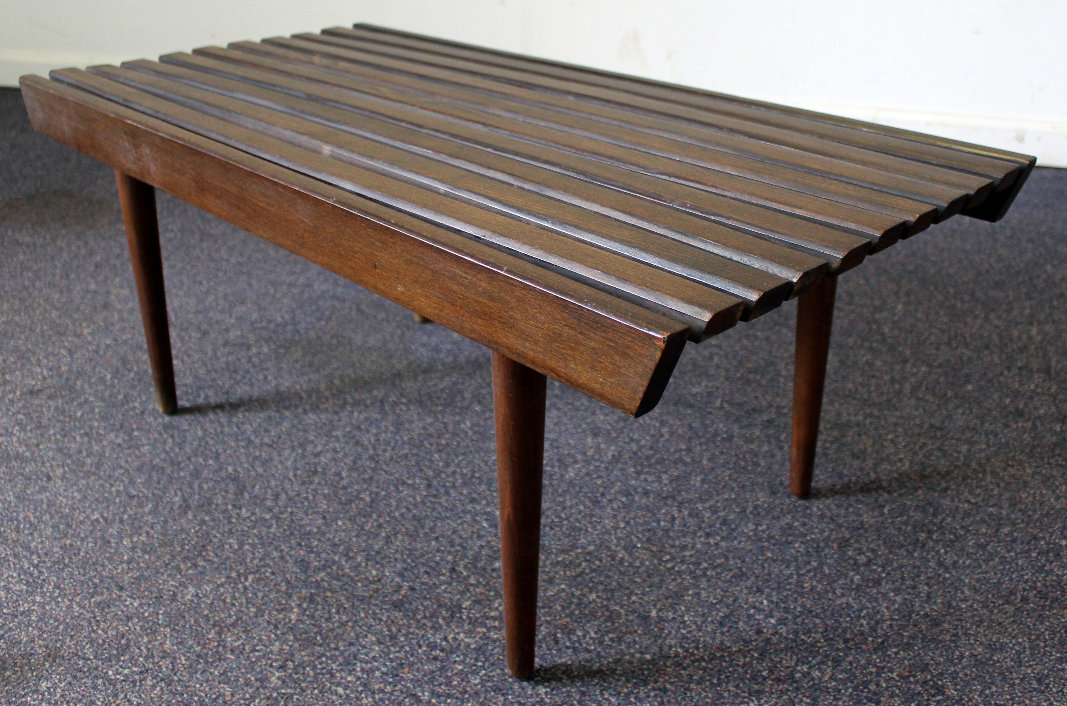 What a find. Offered is a Mid-Century Modern slat bench coffee table. It has a nice look with simple lines. The piece is made of walnut, shows minor wear. It is not signed.

Measures: 36