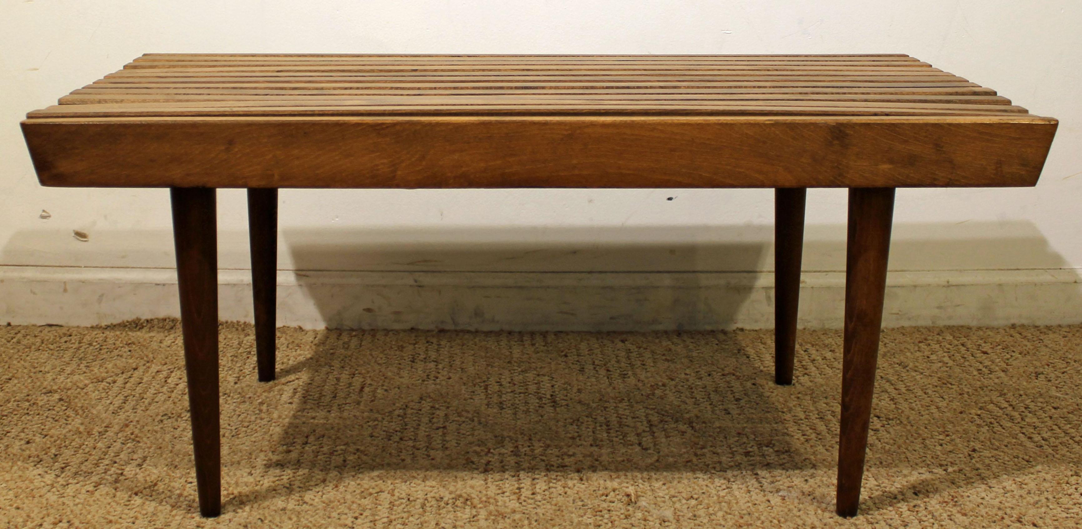 What a find. Offered is a midcentury slat bench coffee table. This table is made of walnut. It is in great condition considering its age, but nothing overly noticeable. It is not signed. 

Dimensions: 
36
