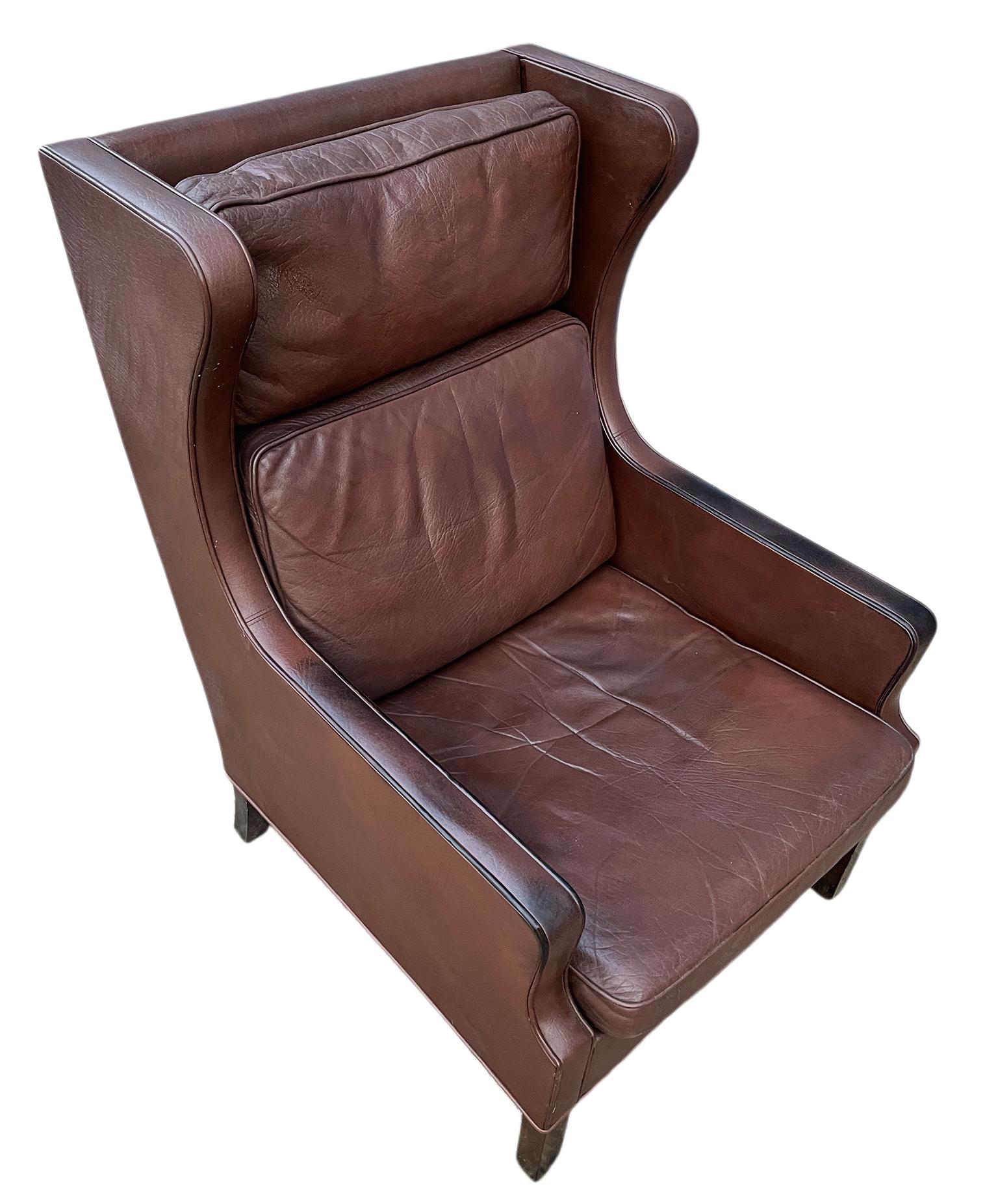 Mid century Danish modern wing back Brown leather fireside chair in the by Børge Mogensen with beautiful patina. Chair shows wear and use. All original vintage used patina. Beautiful soft Dark Brown leather. Solid Teak legs - Made In Denmark.