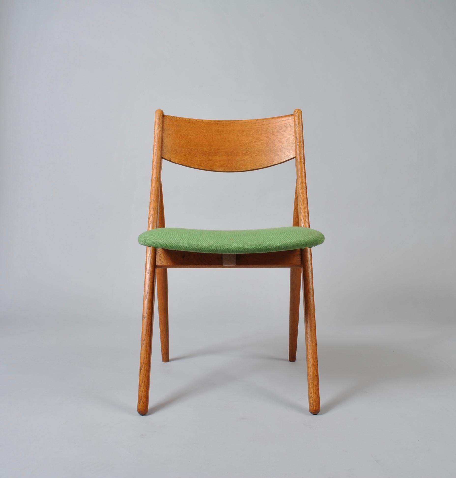 An unusual set of six Danish midcentury oak dining chairs, produced in Denmark, circa 1960. Wonderfully minimal walking leg profile design. Not dissimilar to Hans Wegners sawbuch dining chairs.The frames are in great condition and thoroughly