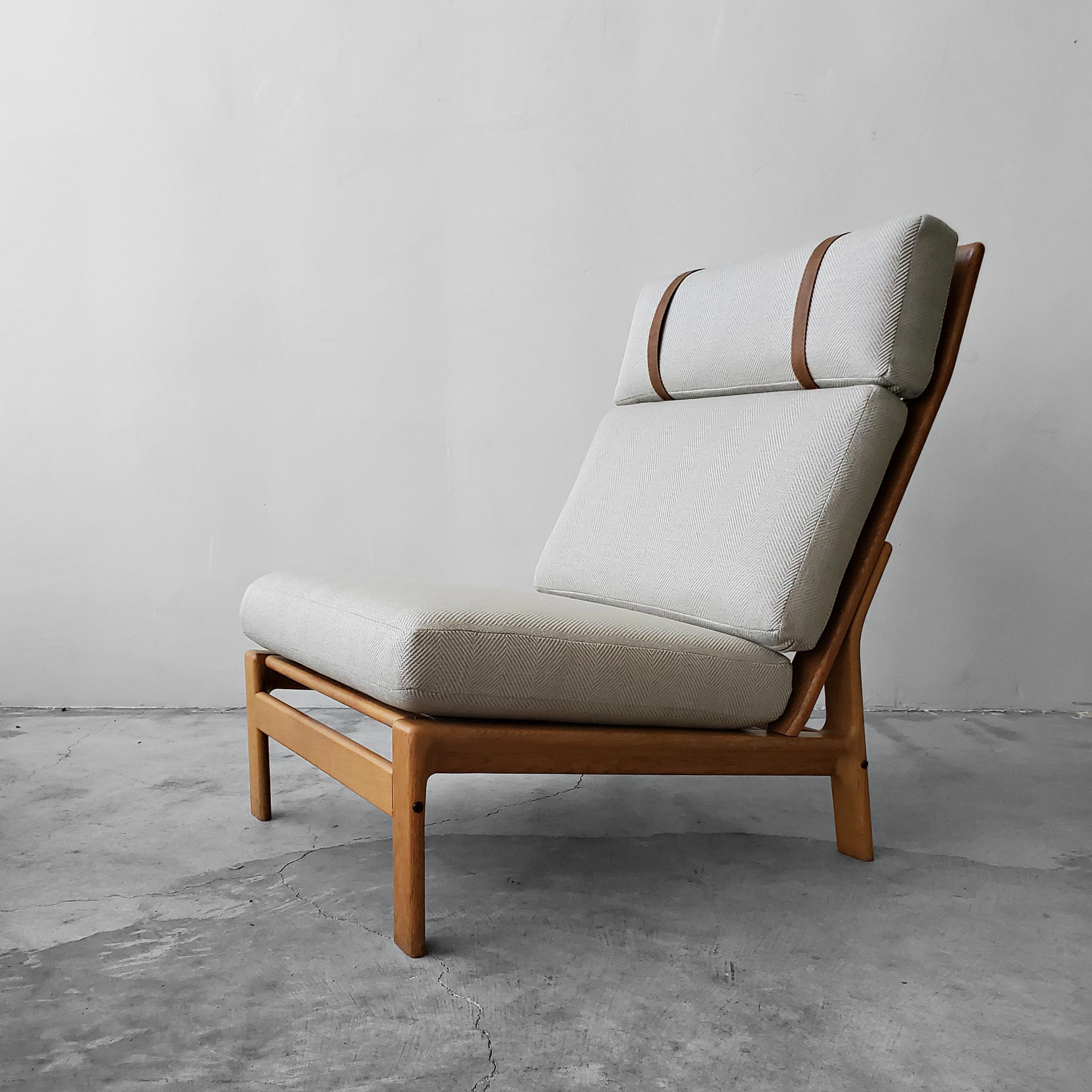 Rare solid oak framed Danish high back lounge chair by Komfort design. This chair had a gently reclined position that give it beautiful lines as well as make it very comfortable.

Chair has been newly upholstered in a high quality herringbone