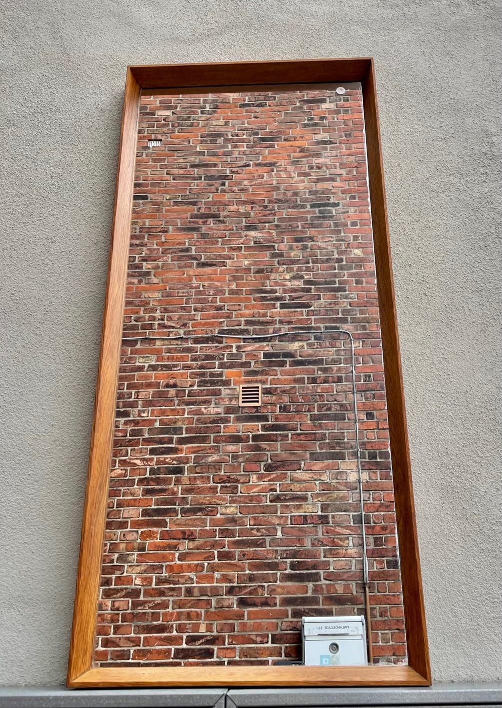 A rare full-size wall mirror with solid oak profiles. Designed for and manufactured in Denmark during the 1960s by Aarhus Glasimport & Glasliberi. It is patented and has the design number: 341A. Original 1960s paper markers mark still present to its