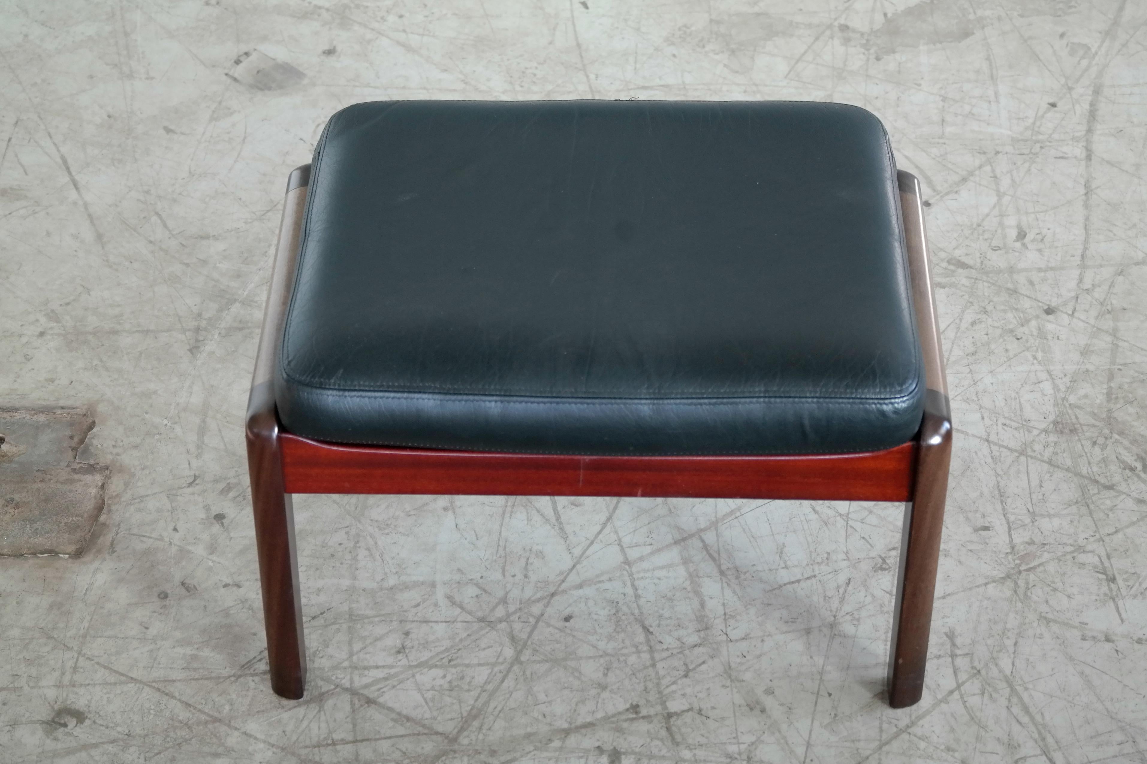 Beautiful ottoman or footstool designed by Ole Wanscher for P. Jeppesen in the 1950s. Manufactured in mahogany and topped with a handstitched leather cushion in supple black leather. A great Danish midcentury high-end design that could be paired