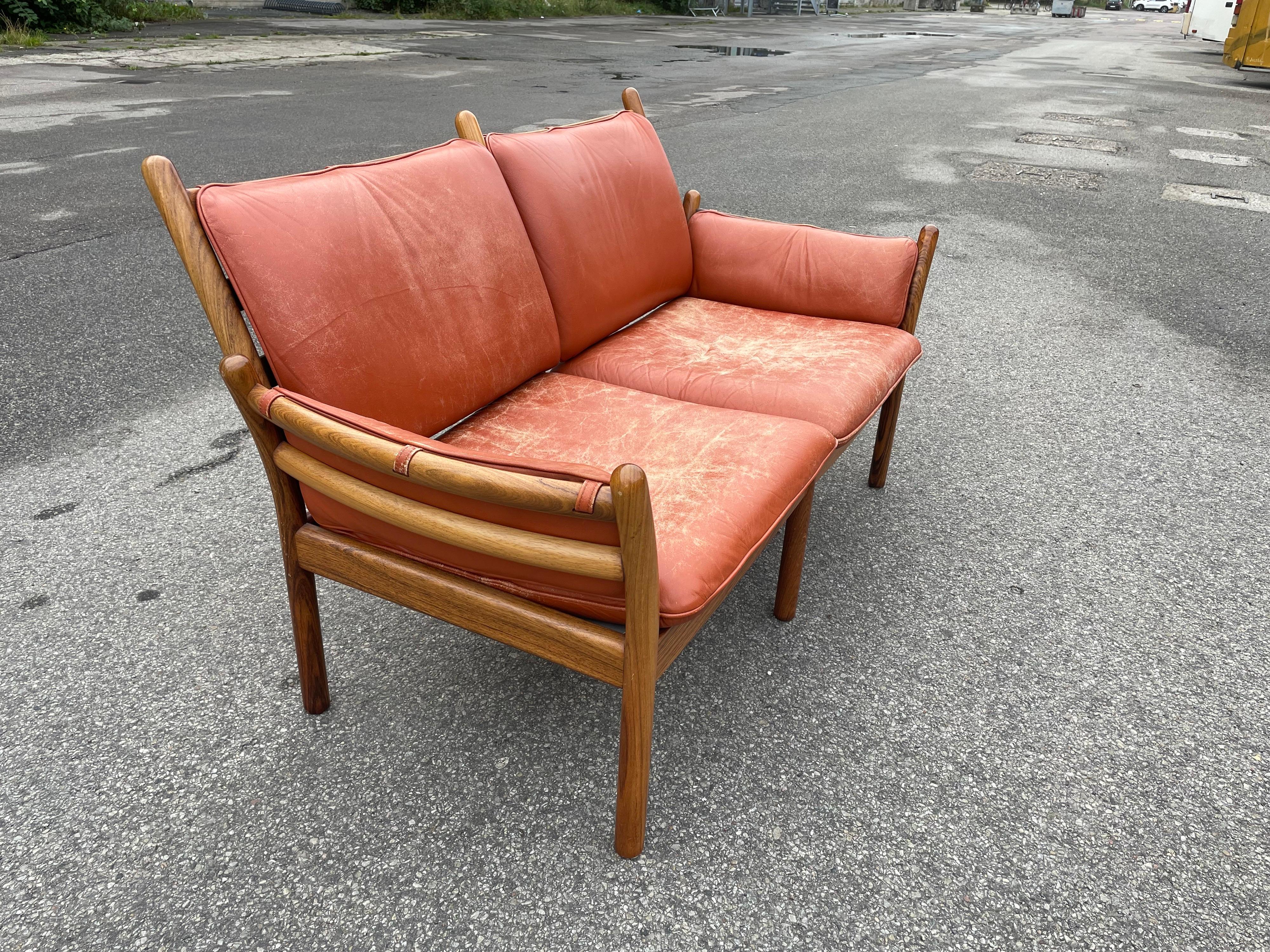 Midcentury Danish rosewood and leather sofa by Illum Wikkelsø for CFC Silkeborg. Beautiful organic design with joinery resembling a tree branch, between the sides and back. An overall attention to the details, that make this two-seat an incredible