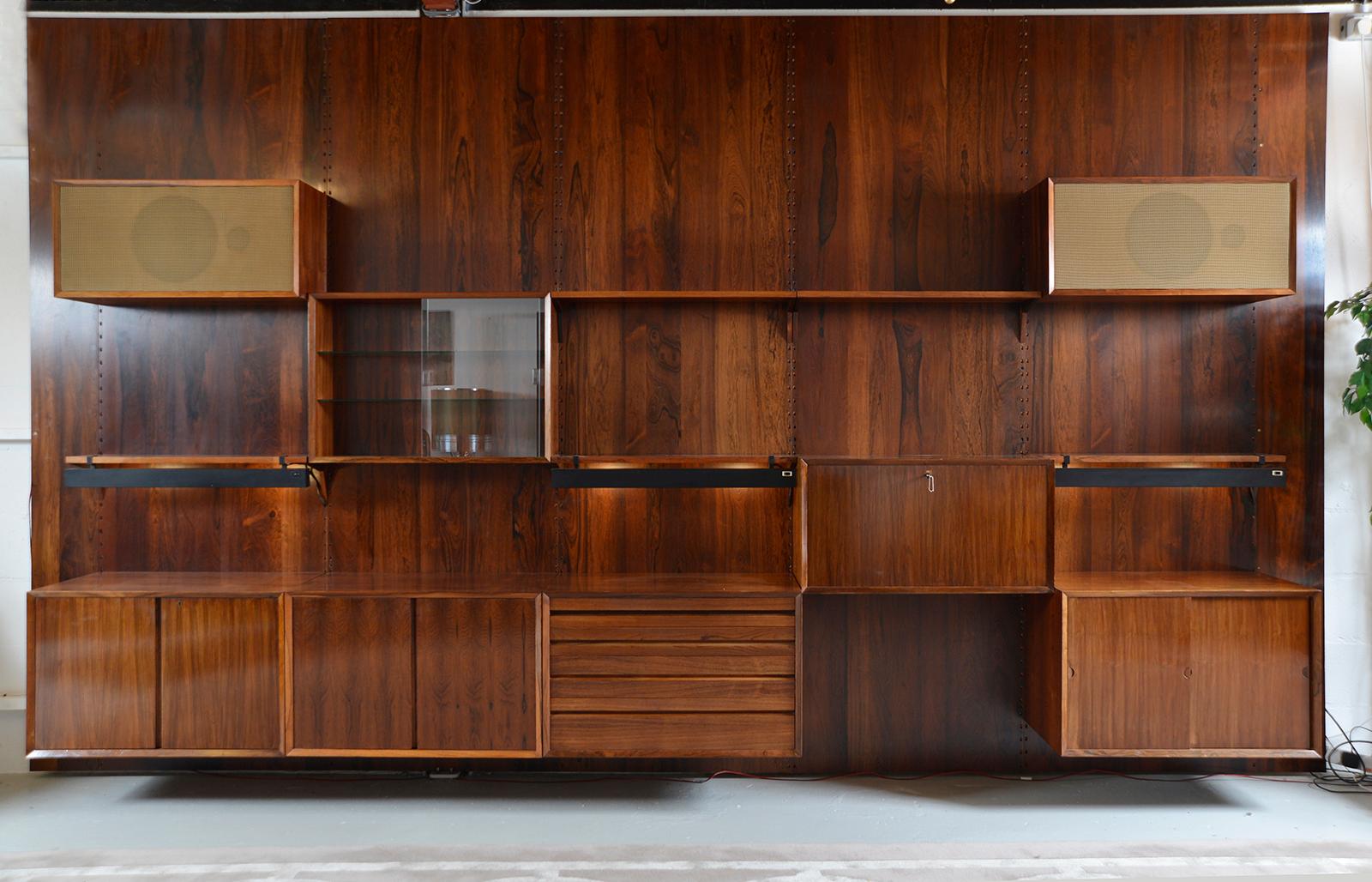 This particular system is commonly referred to as ‘Cado’ to differentiate it from the ‘Royal System', also designed by Poul Cadovius. 
The spectacular modular rosewood wall system is in really lovely condition with stunning figuring, showing only