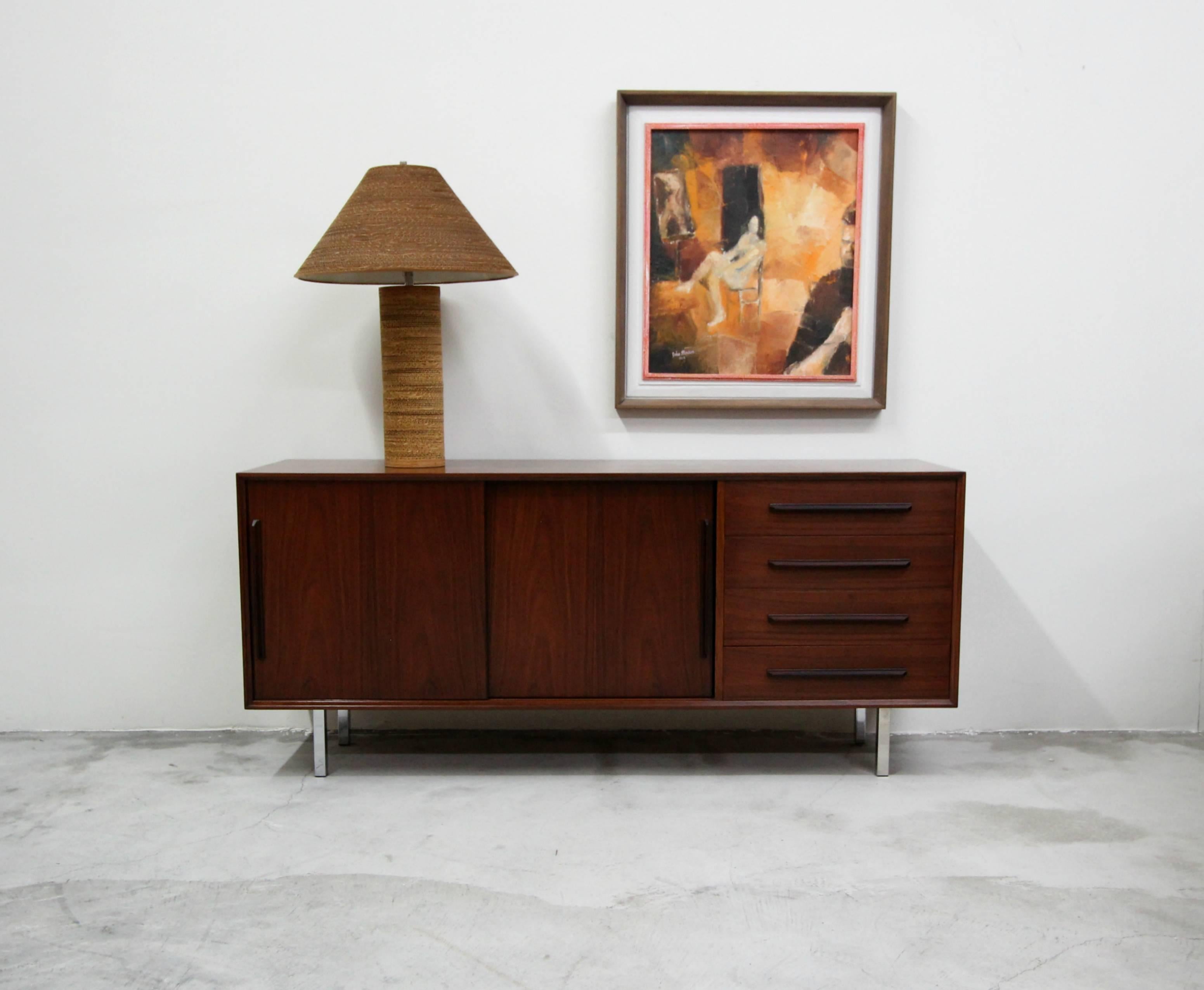 Beautiful midcentury rosewood credenza sideboard this credenza is so simple but absolutely gorgeous. The credenza has the most beautifully grained rosewood and chrome legs. A classic Danish piece. This credenza is a bit more petite than most, making