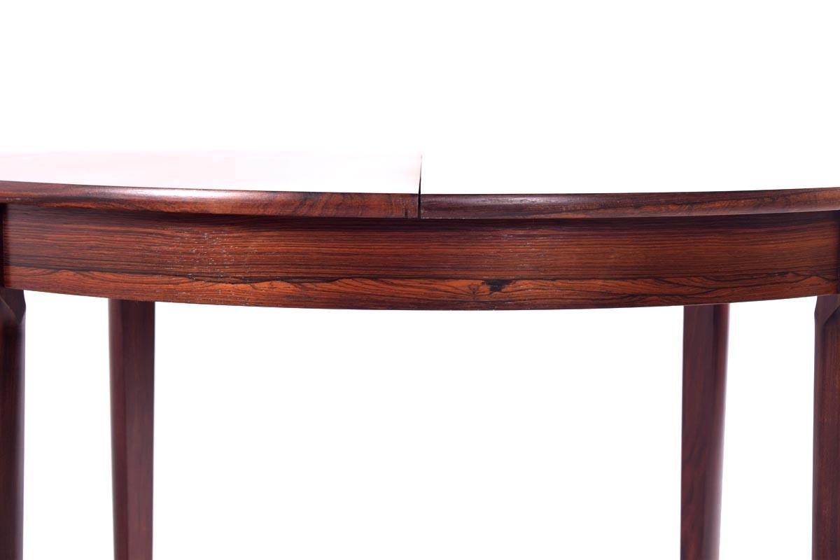 Danish extendable table with two hidden leaves of 35 cm each. The table extends to 193 cm. Each leaf can be added separately and they hide inside the tabletop. Legs are made out of solid rosewood. The piece is sturdy and the extending mechanism is