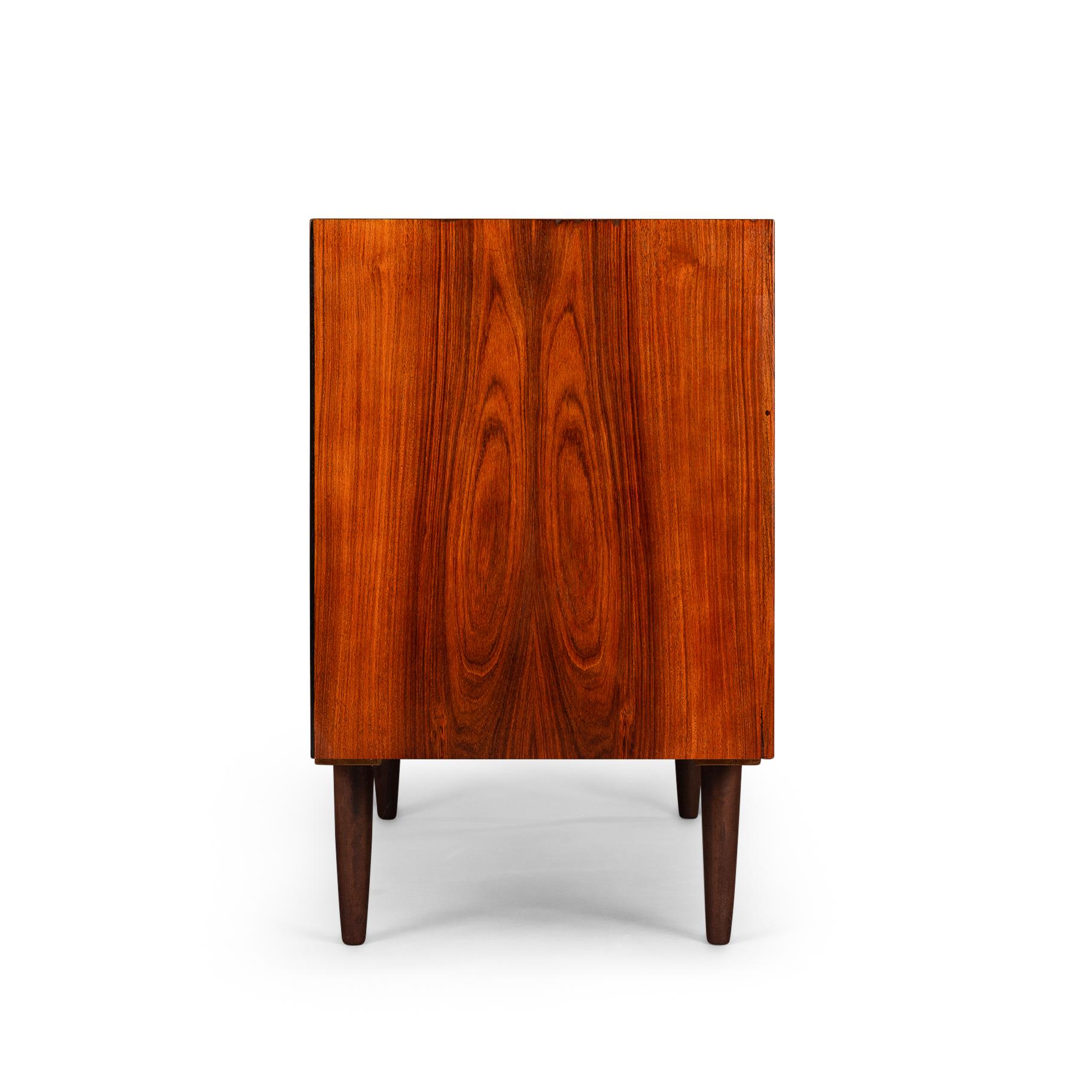 Rosewood anybody?! This medium sized sideboard is all about the print and colour of the rosewood veneer. Very much an eye catcher in any modern and light interior. It has the design signature of Brouer all over it with it's top veneer in dark red