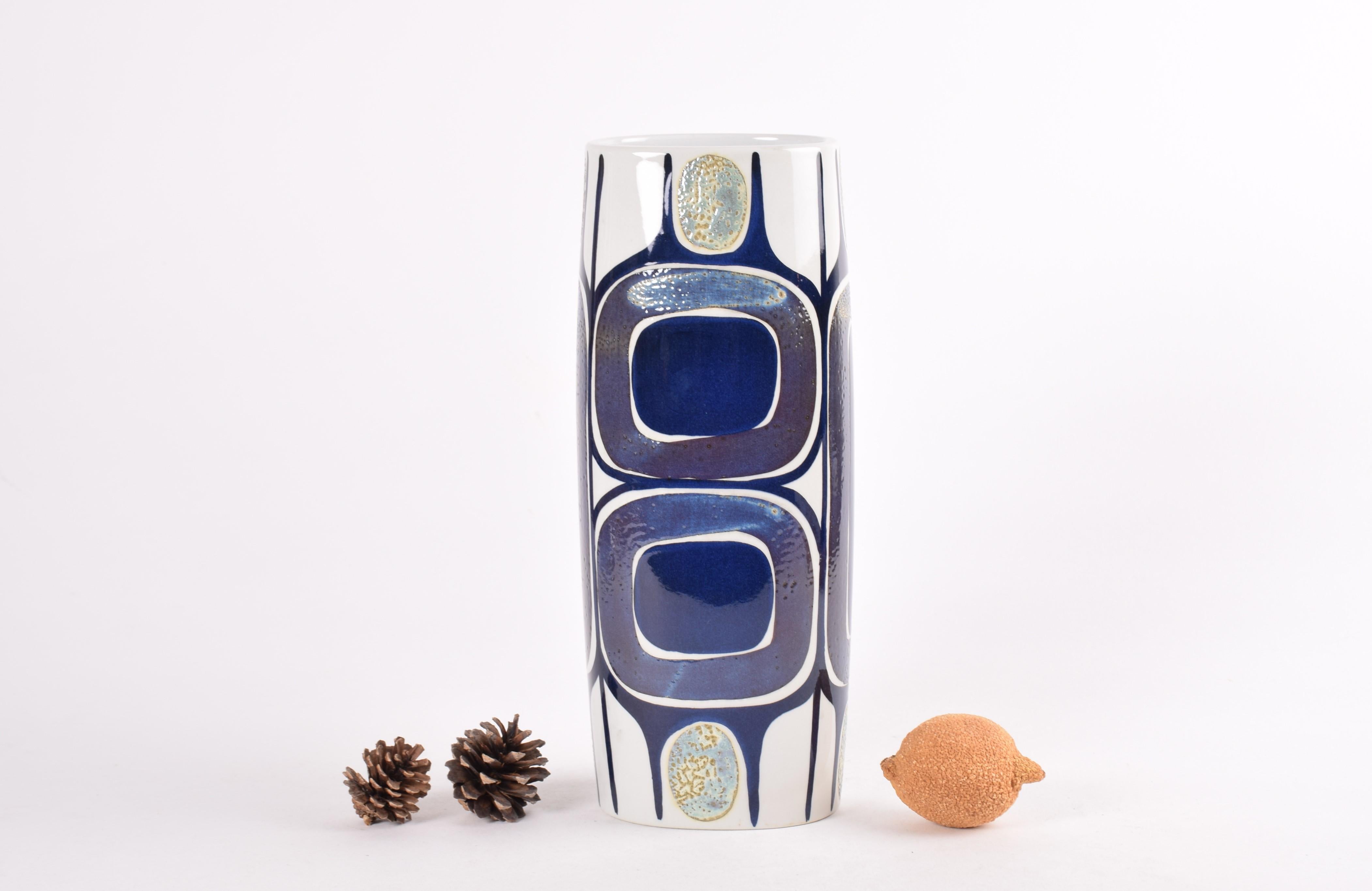Tall and eye-catching vase from the Royal Copenhagen Tenera series.
The bold hand painted decor is designed by Inge-Lise Koefoed.
The colors are blue and purple and shimmering pale yellow or gold on white.

The vase was manufactured in the period