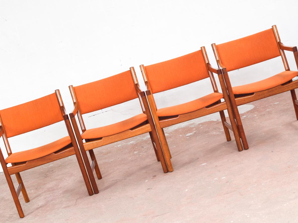 Midcentury set of 4 chairs designed by Hans Wegner and manufactured by Johannes Hansen in Denmark in the 1960s. Less known model with arm rests. The chairs are made of solid teak. The orange fabric is original and has some less visible stains. The