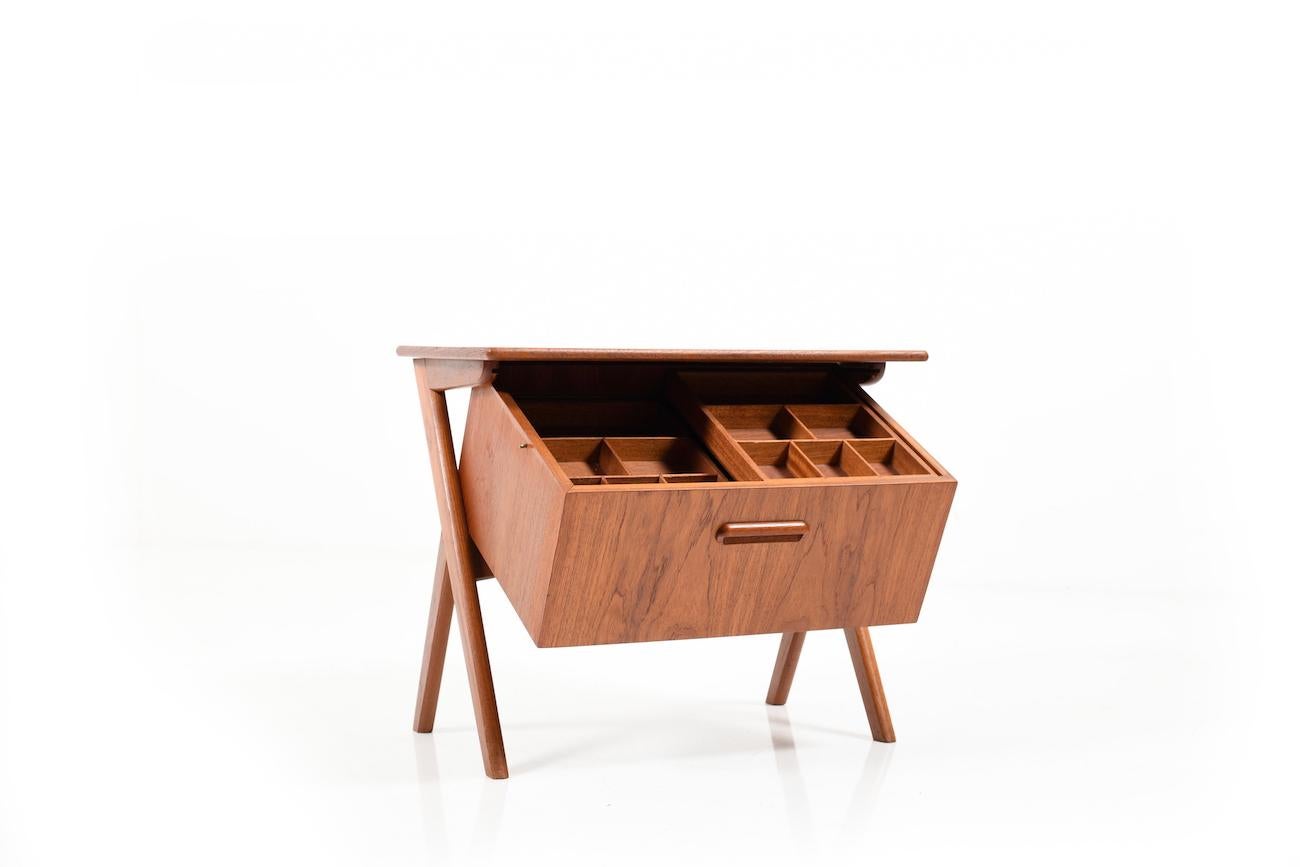 Nice Danish sewing table in teak. Below the tabletop is a drawer that can be opened diagonally forward. Inside there are two compartments that move back and forth. As a whole, there is then stowage space for all important sewing utensils in the