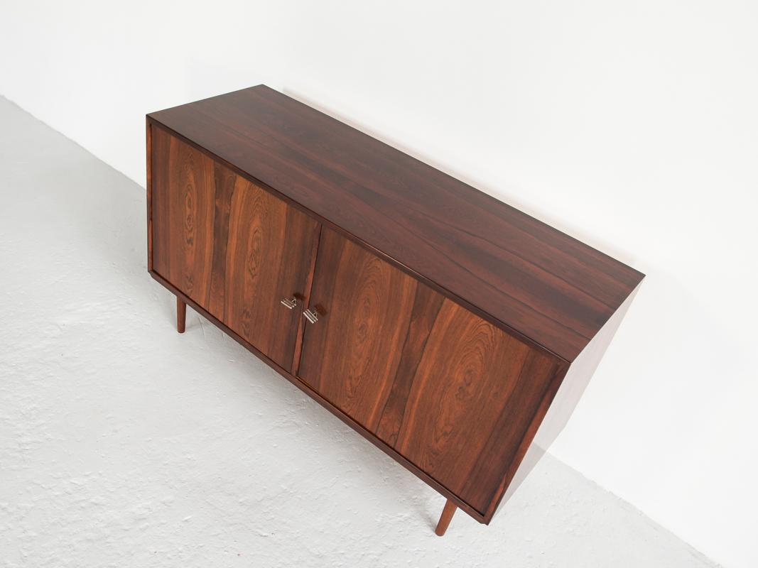 This midcentury sideboard was made in Denmark in the 1960s. True high quality manufacturing in rosewood with beautiful veneer selection. The sideboard has 7 drawers inside and the original keys. It is in very good condition.