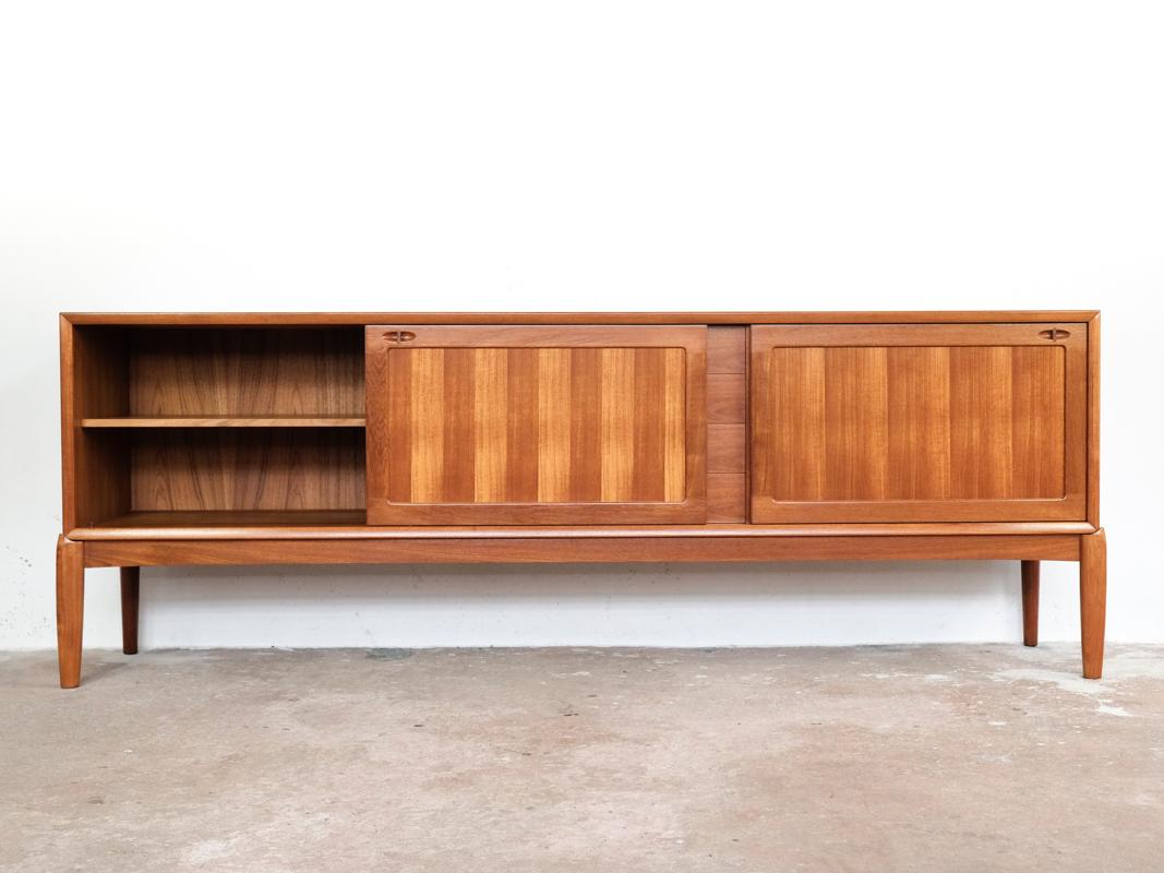 Midcentury sideboard designed by H. W. Klein and manufactured by Bramin in Denmark in the 1960s. The sideboard has a specific design of the front legs as well as the door and drawer handles. The legs are at the corners of the sideboard. The
