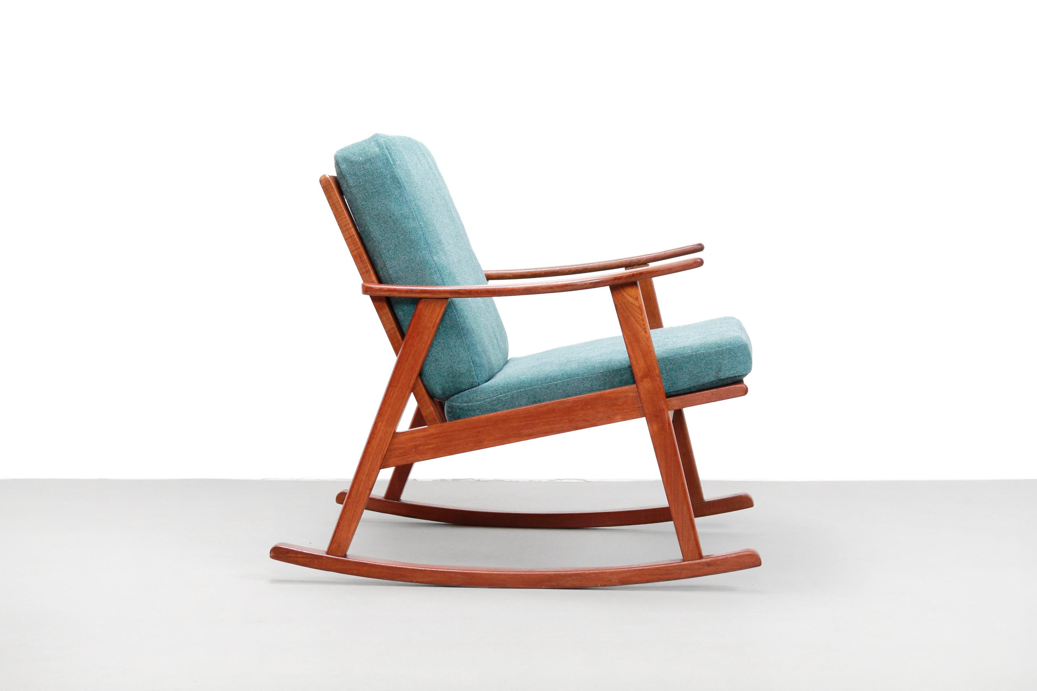 Teak wooden rocking armchair of Danish origin. This rocking chair is made of solid teak. The cushions are provided with a new fabric. Given that the chair is made of solid teak, and how sturdy it is after 60 years, this must be a chair that came