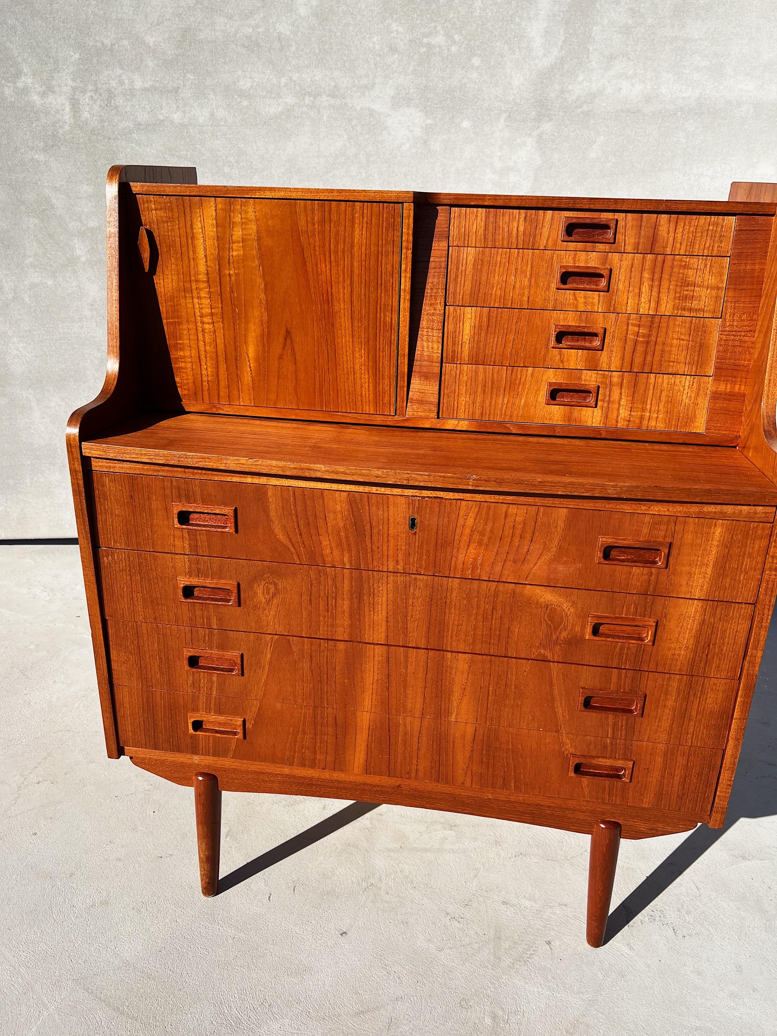 A newly refinished Danish teak desk or vanity 

This secrétaire is incredibly versatile with four small drawers, four large drawers, a small cabinet with inner shelving, a pullout writing desk shelf, even a hidden mirror 

Marked by maker on the